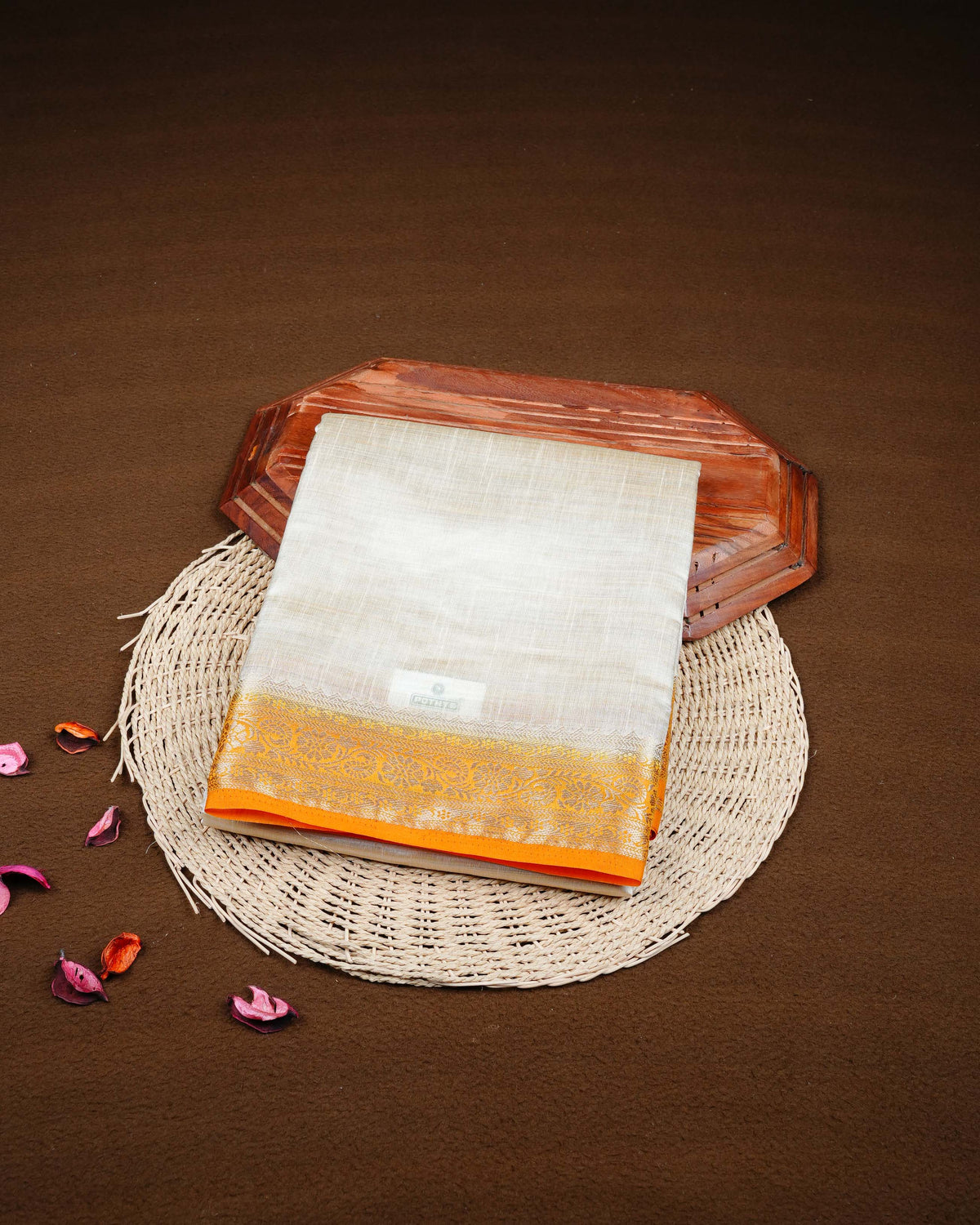 Cream colour Tussar silk saree Featuring Plain body, complemented by Contrast light orange colour gold zari floral patterns on border, paired with matching blouse piece.
