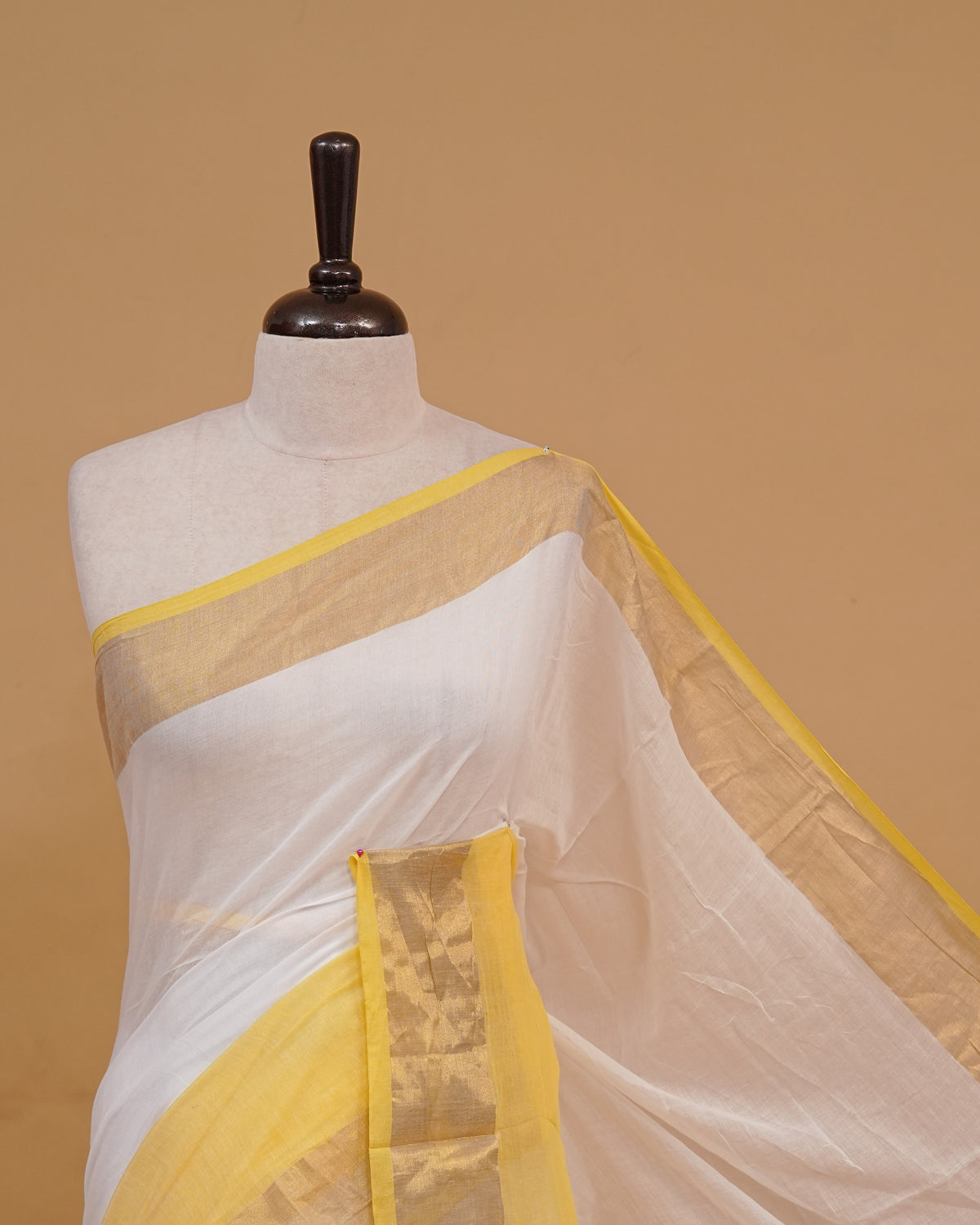 White colour Mul cotton saree featuring Elegant Plain body, complemented by contrast yellow & gold zari border & Tassels.