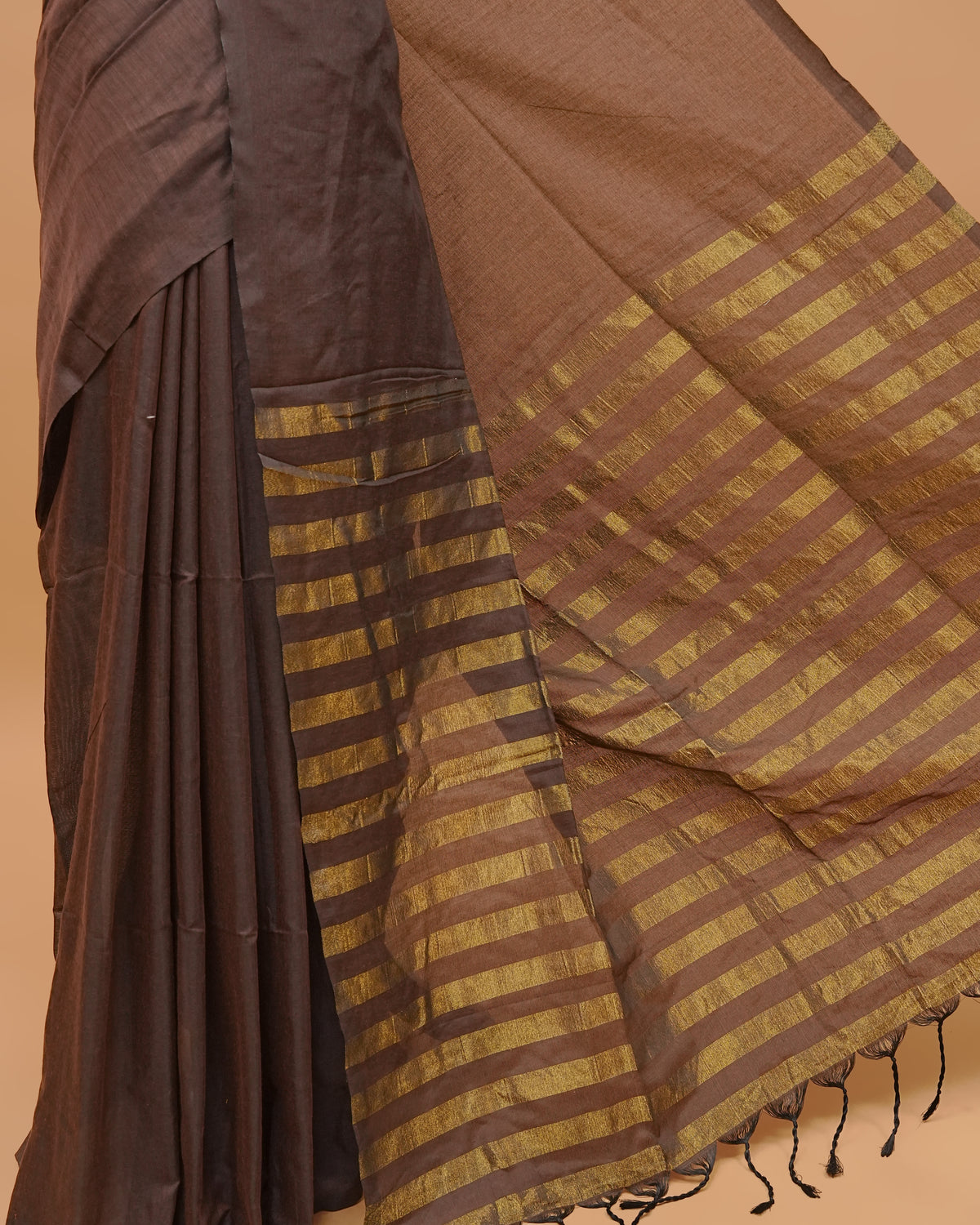 Brown Colour Mul Cotton Saree Featuring Plain body. With out Border Golden Strips on pallu comes With Tassels