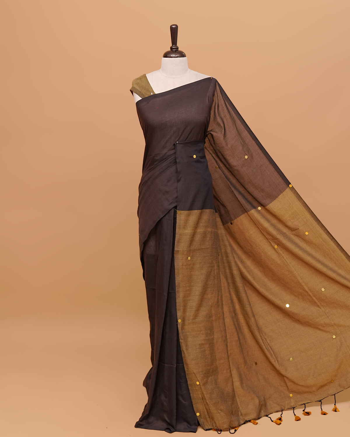 Black and Olive coloured half and half mul cotton saree featuring elegant sequin detailing on the body, finished with a beautiful pallu adorned with tassels.