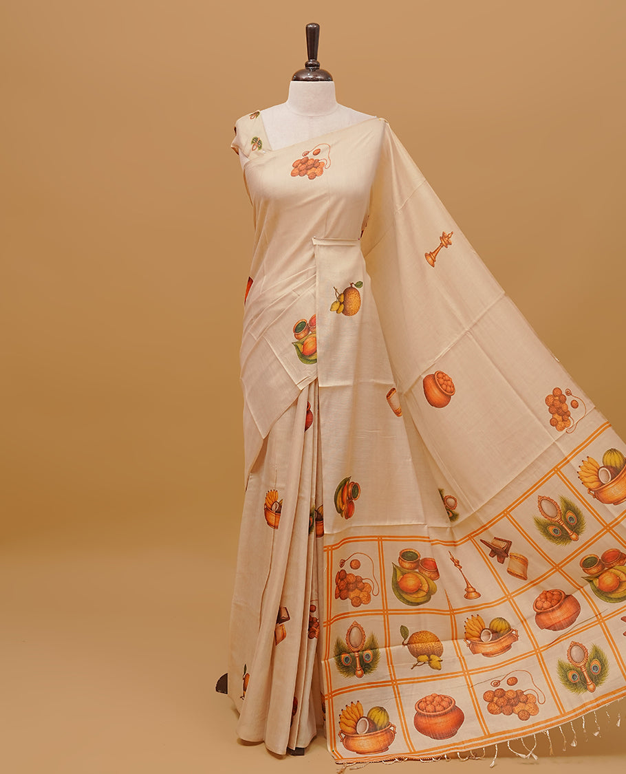 Cream colour semi tissue saree featuring Vishu theme prints on the body, without border & pallu finished with tassels. Paired with a matching blouse piece.