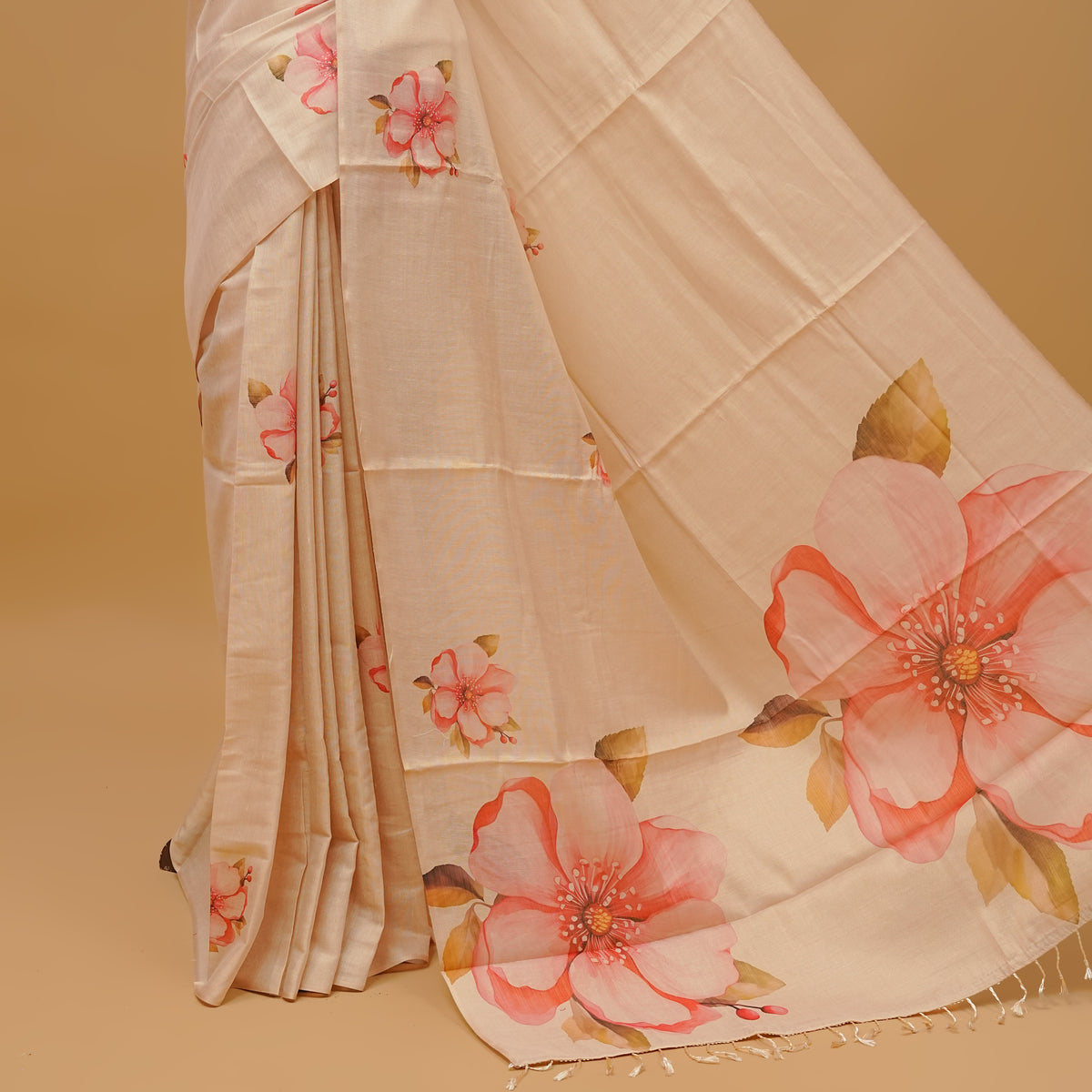 Cream colour semi tissue saree featuring floral prints on body, borderless design & pallu finished with tassels. Paired with a matching blouse piece.