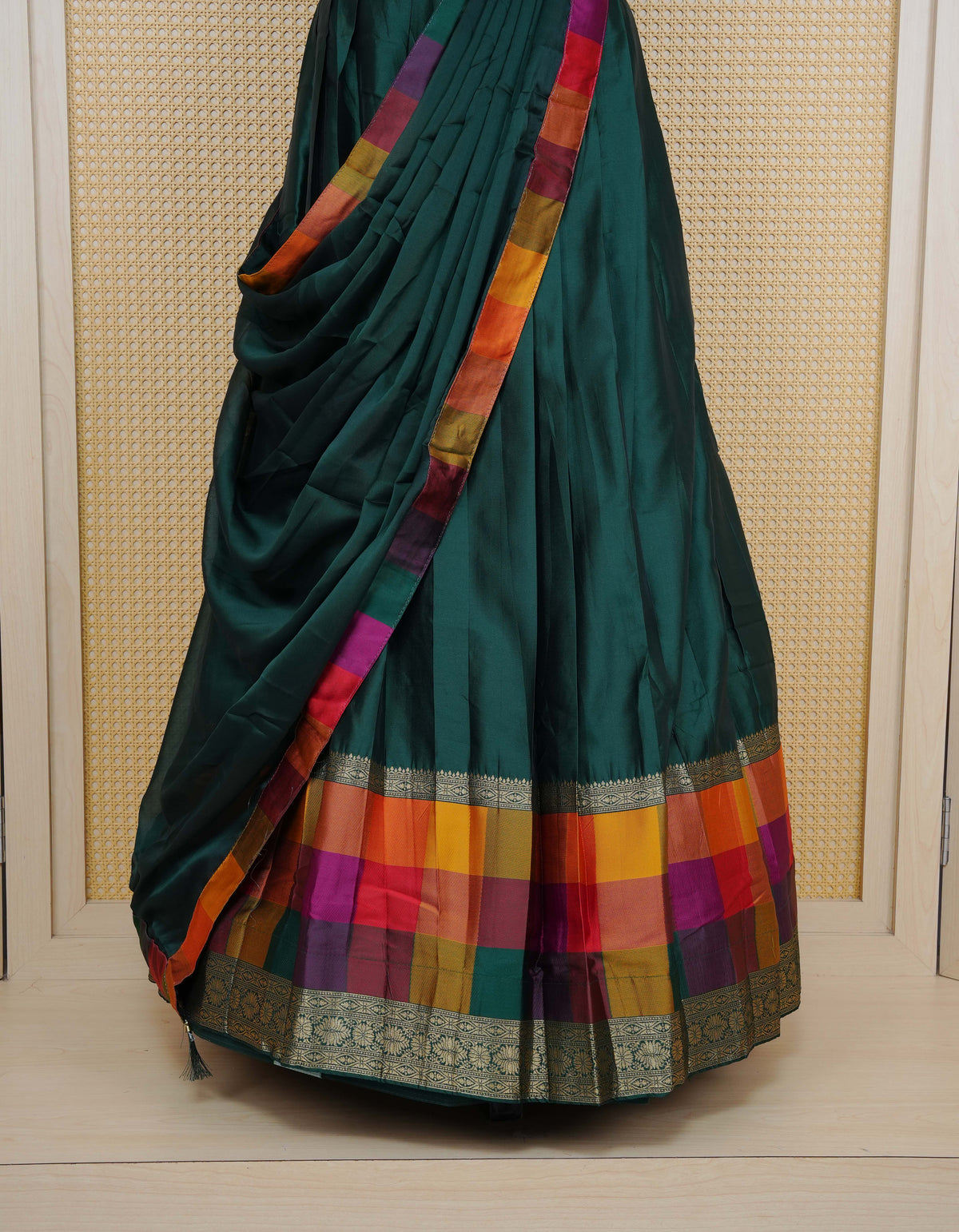 Bottle green colour Semi Silk Semi stitched dhavani set featuring a Plain body with a matching Multi colour with gold zari bordered skirt & blouse piece and dupatta.