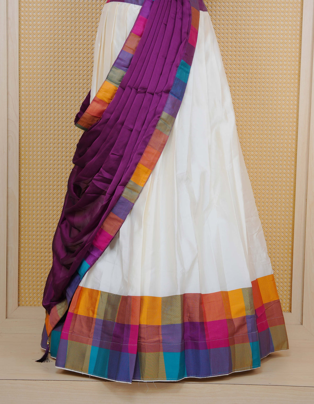 Cream colour Semi Silk Semi stitched dhavani set featuring a Plain body with a matching Multi colour with gold zari bordered skirt & blouse piece and dupatta.