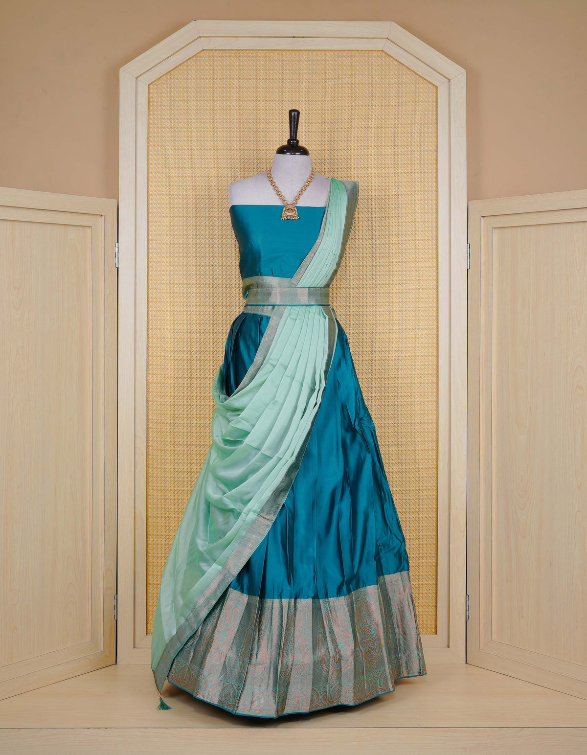 Peacock Green colour semi silk semi stitched dhavani set featuring a Plain body with a matching copper zari bordered skirt & blouse piece and dupatta.