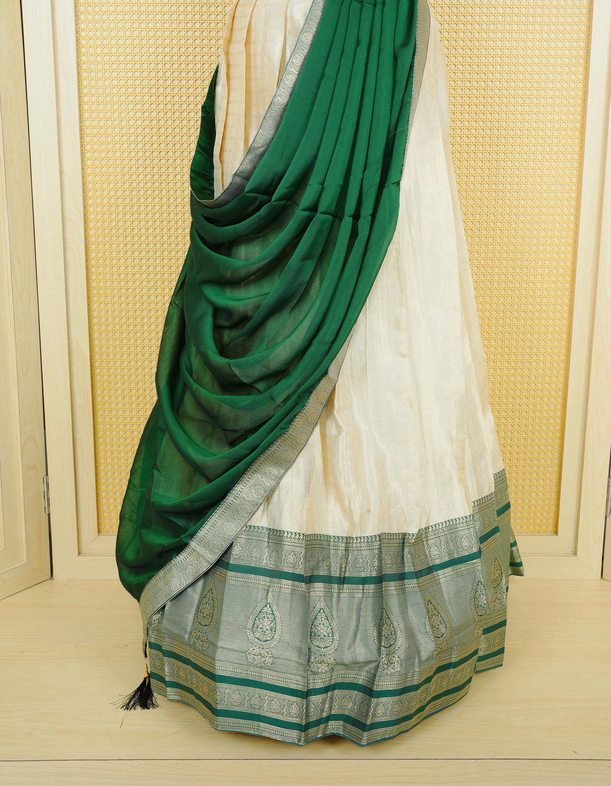 Cream colour tissue semi stitched dhavani set featuring gold zari Check patterns with motifs on the body and a matching Contrast Green colour with gold zari bordered skirt & blouse piece and dupatta.