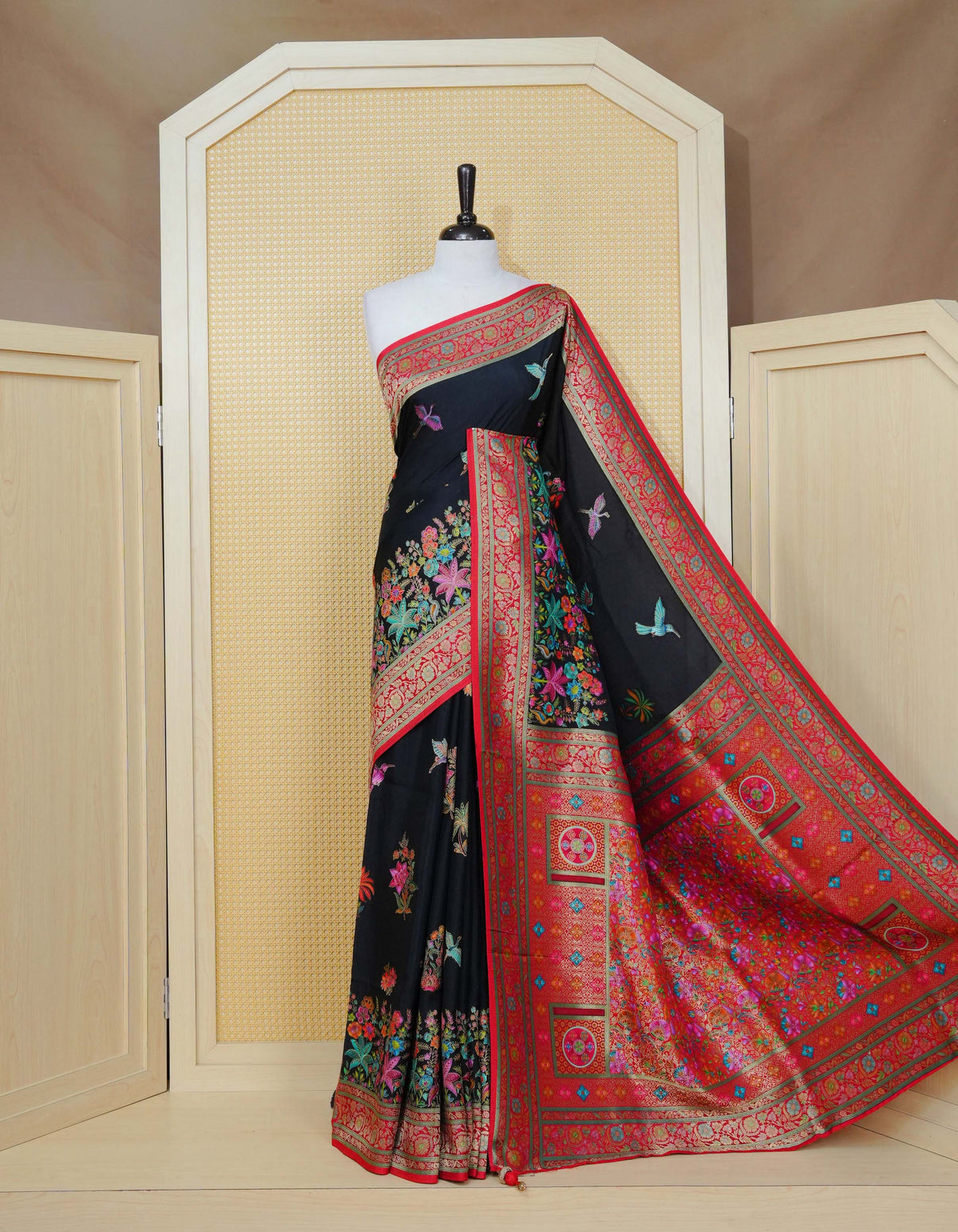 Black Colour Pashmina Saree featuring multi colour flower patterns on body, complemented by Contrast red colour floral motifs zari patterns on border and Pallu, comes with matching blouse piece