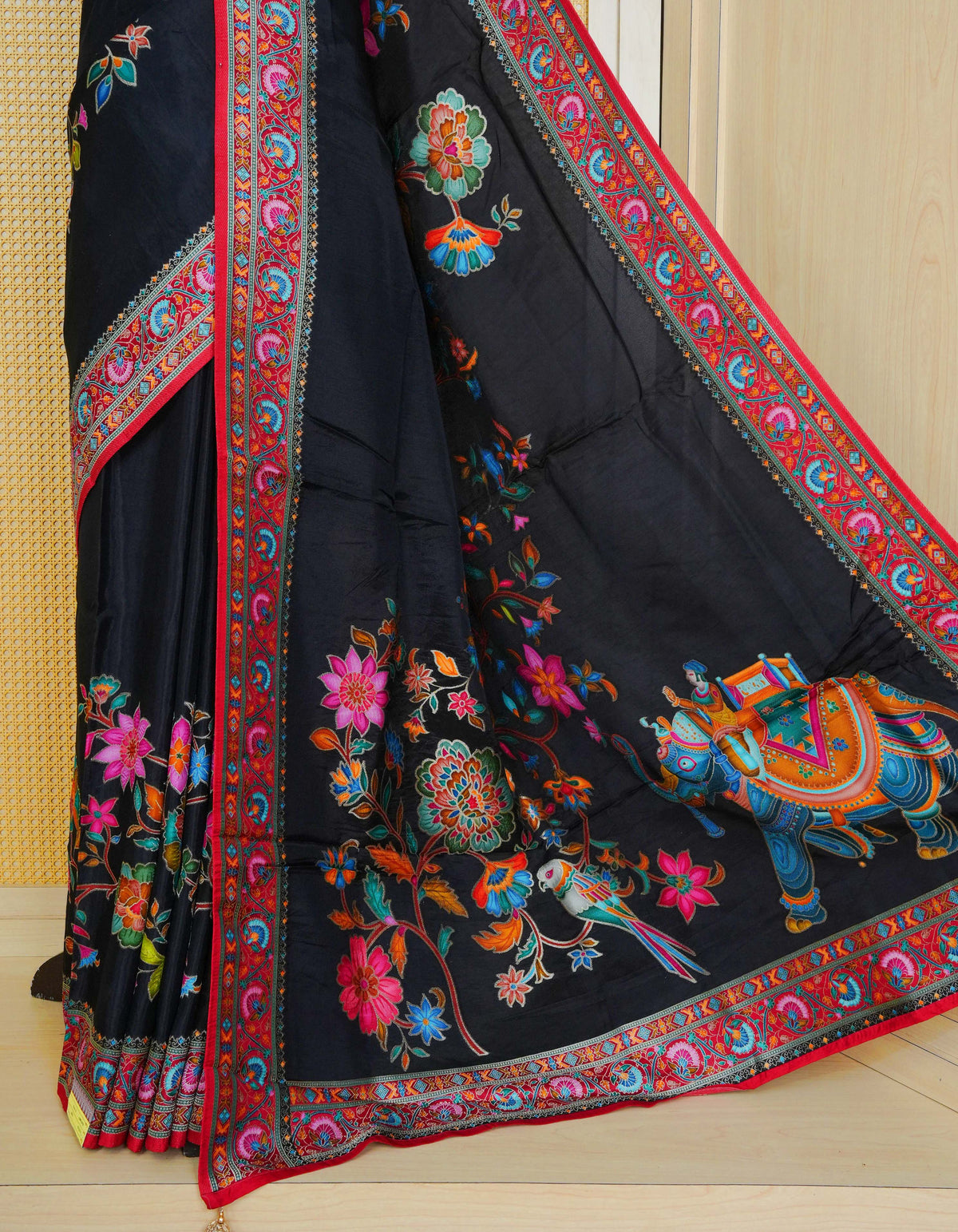 Black Colour Pashmina Saree featuring multi colour patterns on body, complemented by Contrast red colour floral motifs zari patterns on border and Pallu, comes with matching blouse piece