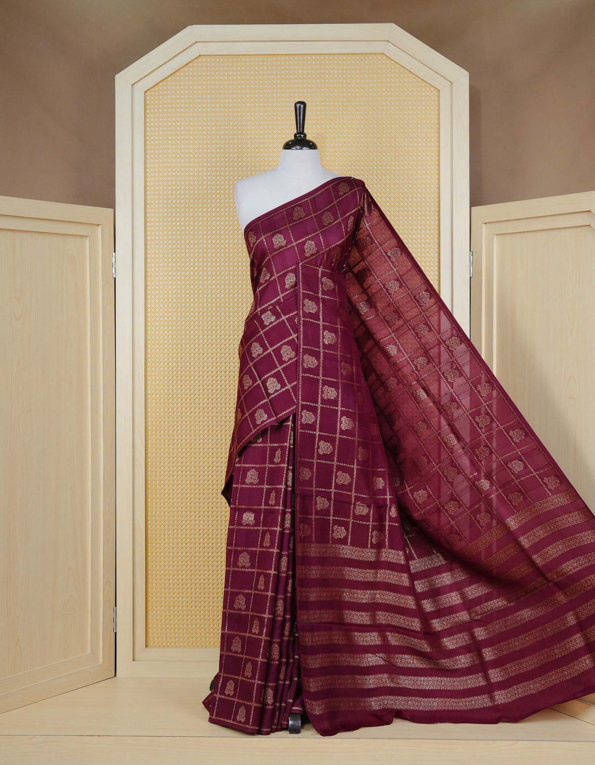 Wine colour semi banaras tussar georgette saree featuring gold zari check with motifs on body, no specific border and paired with matching blouse piece.