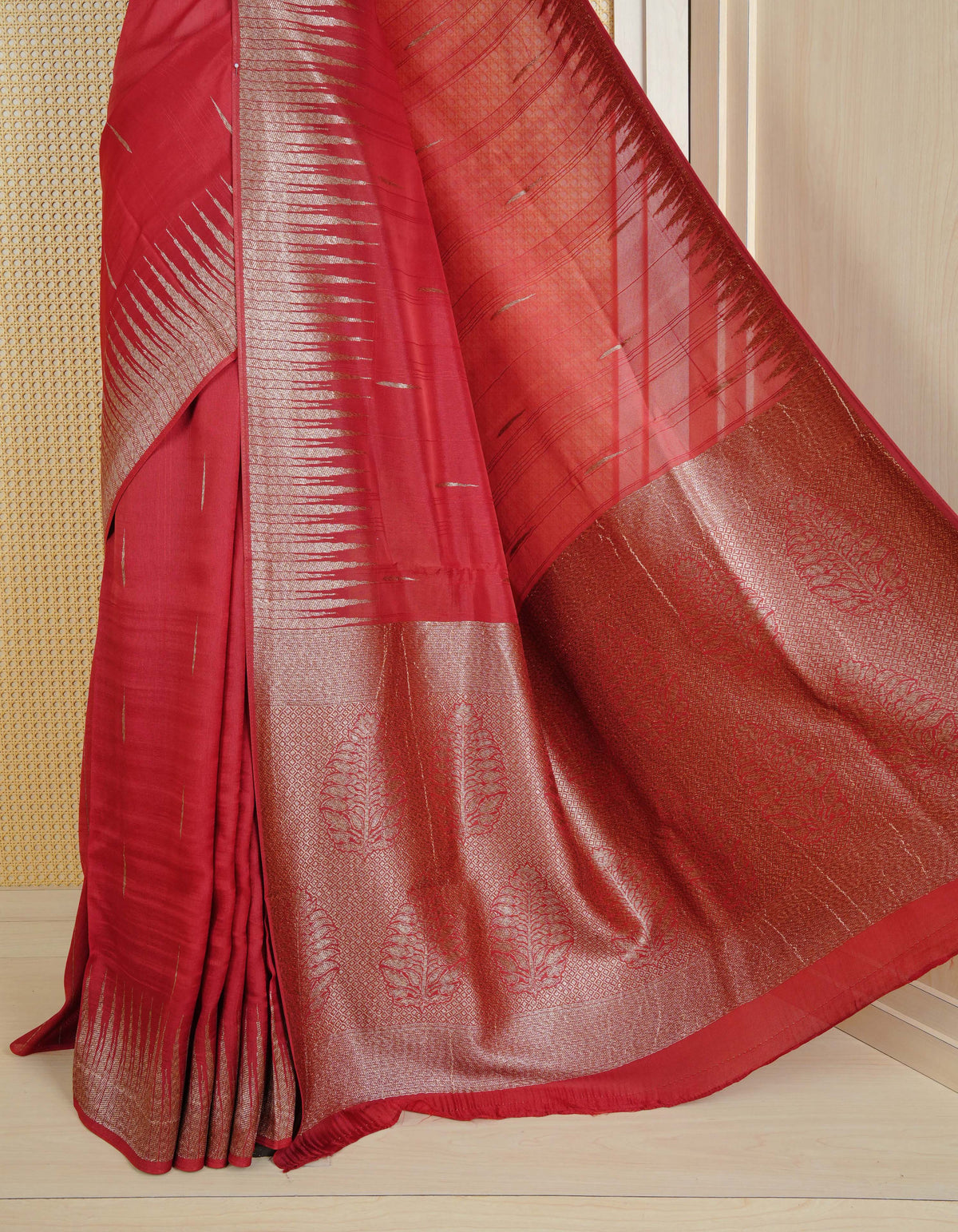Brick red colour semi banaras tussar georgette saree featuring gold zari pattern on body, finished with gold zari temple border and paired with matching blouse piece.