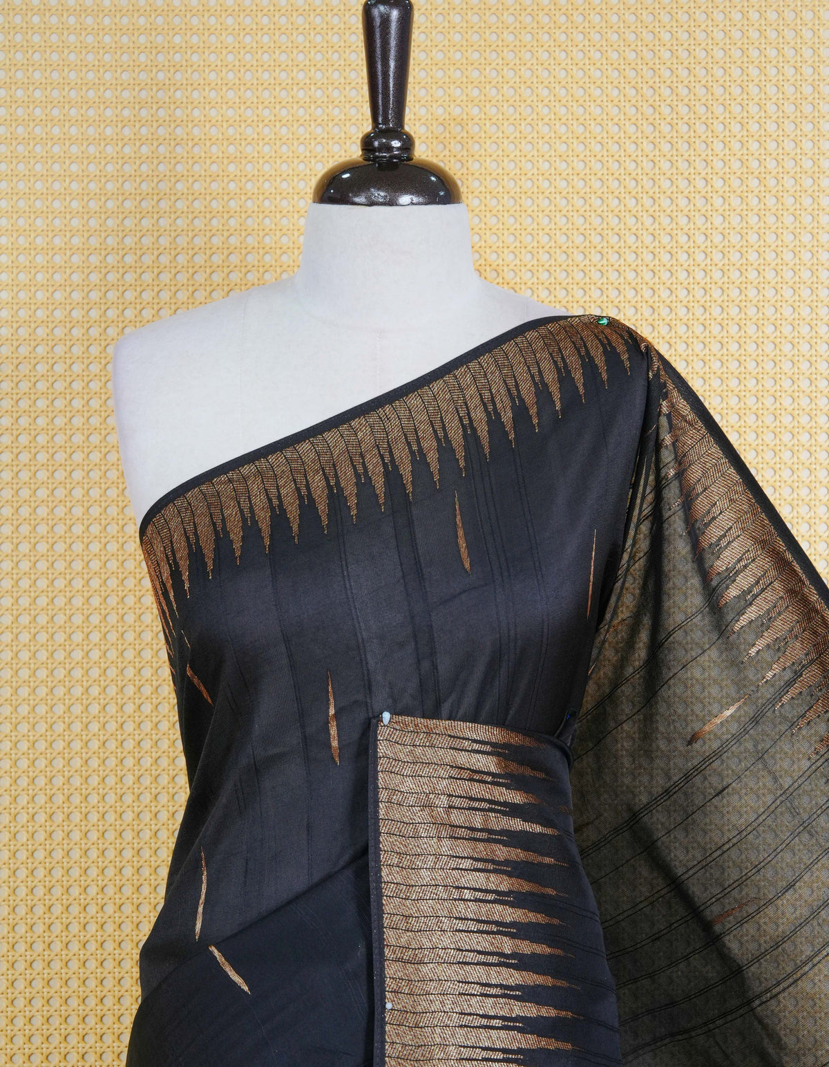 Black colour semi banaras tussar georgette saree featuring gold zari pattern on body, finished with gold zari temple border and paired with matching blouse piece.