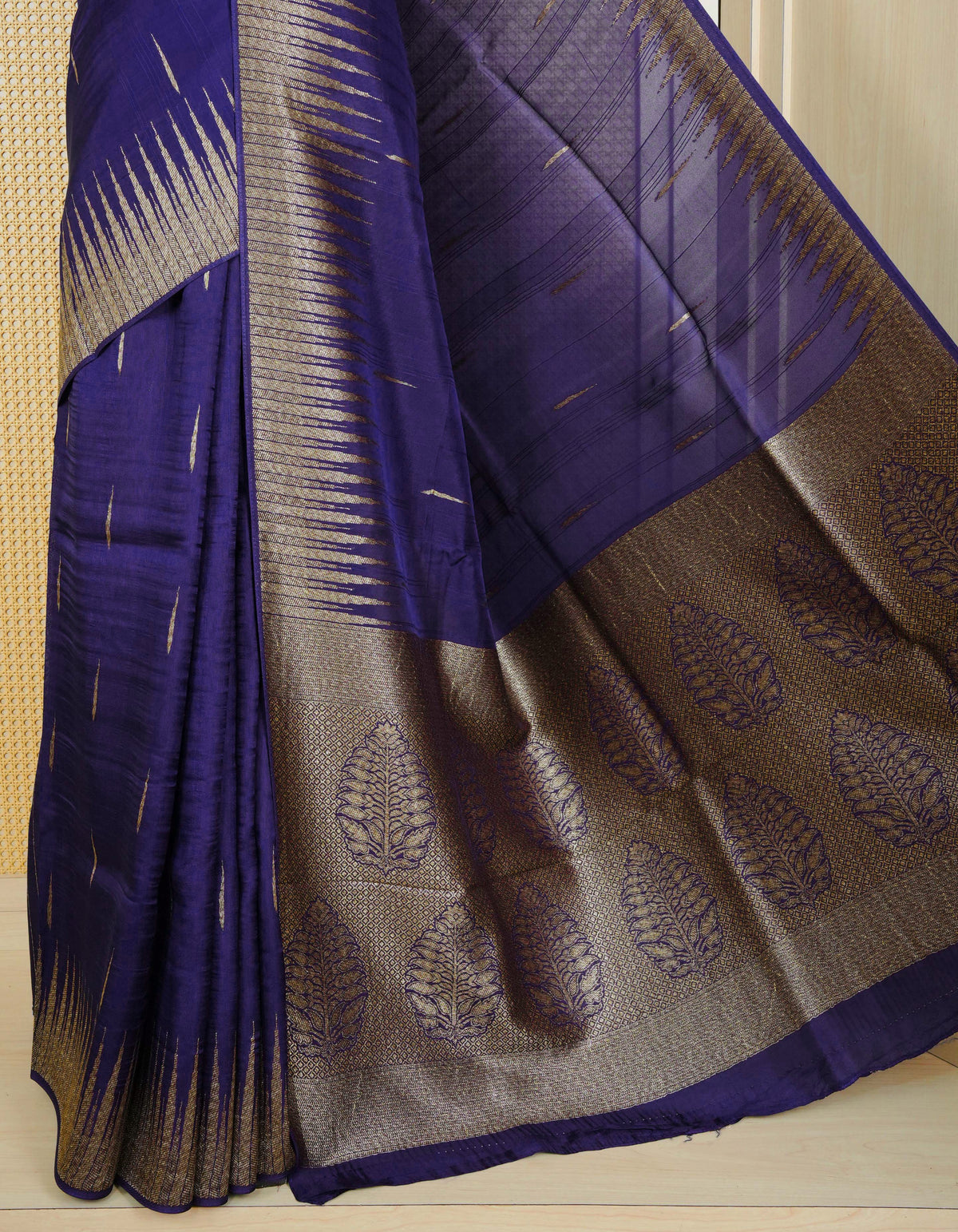 Dark blue colour semi banaras tussar georgette saree featuring gold zari pattern on body, finished with gold zari temple border and paired with matching blouse piece.