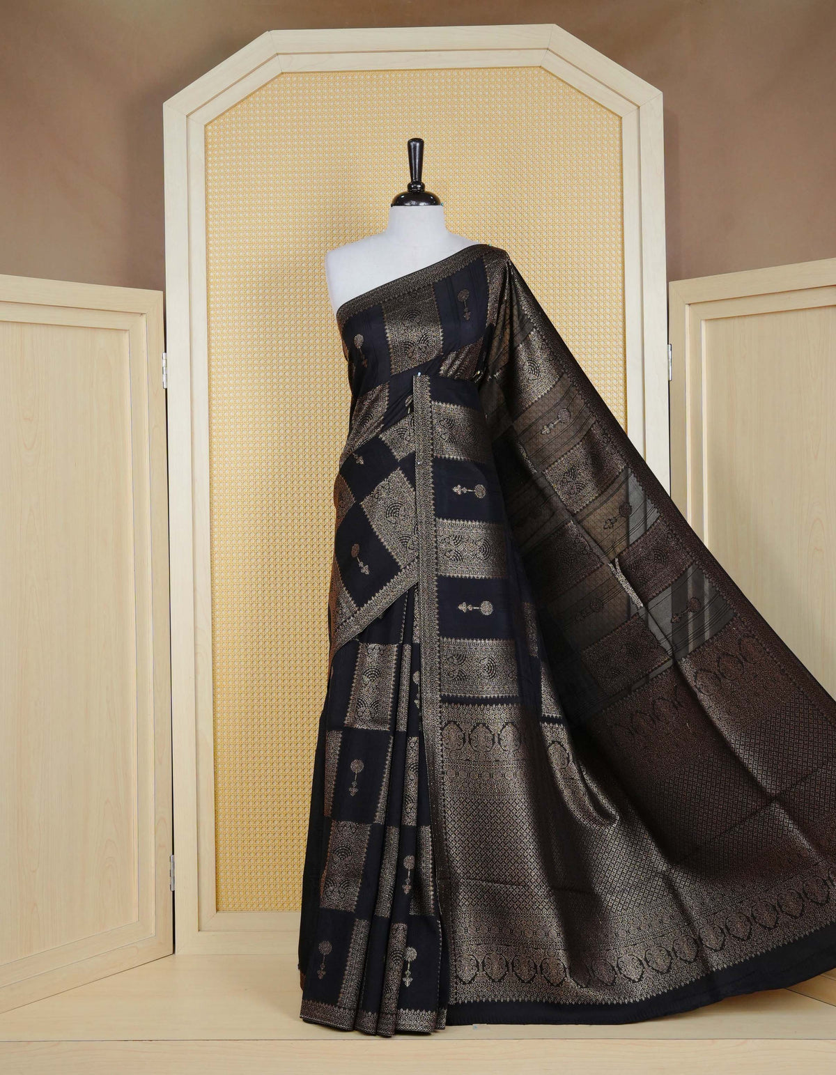 Black colour semi banaras tussar georgette saree featuring gold zari box pattern with motifs on body, finished with gold zari fancy border and paired with matching blouse piece.