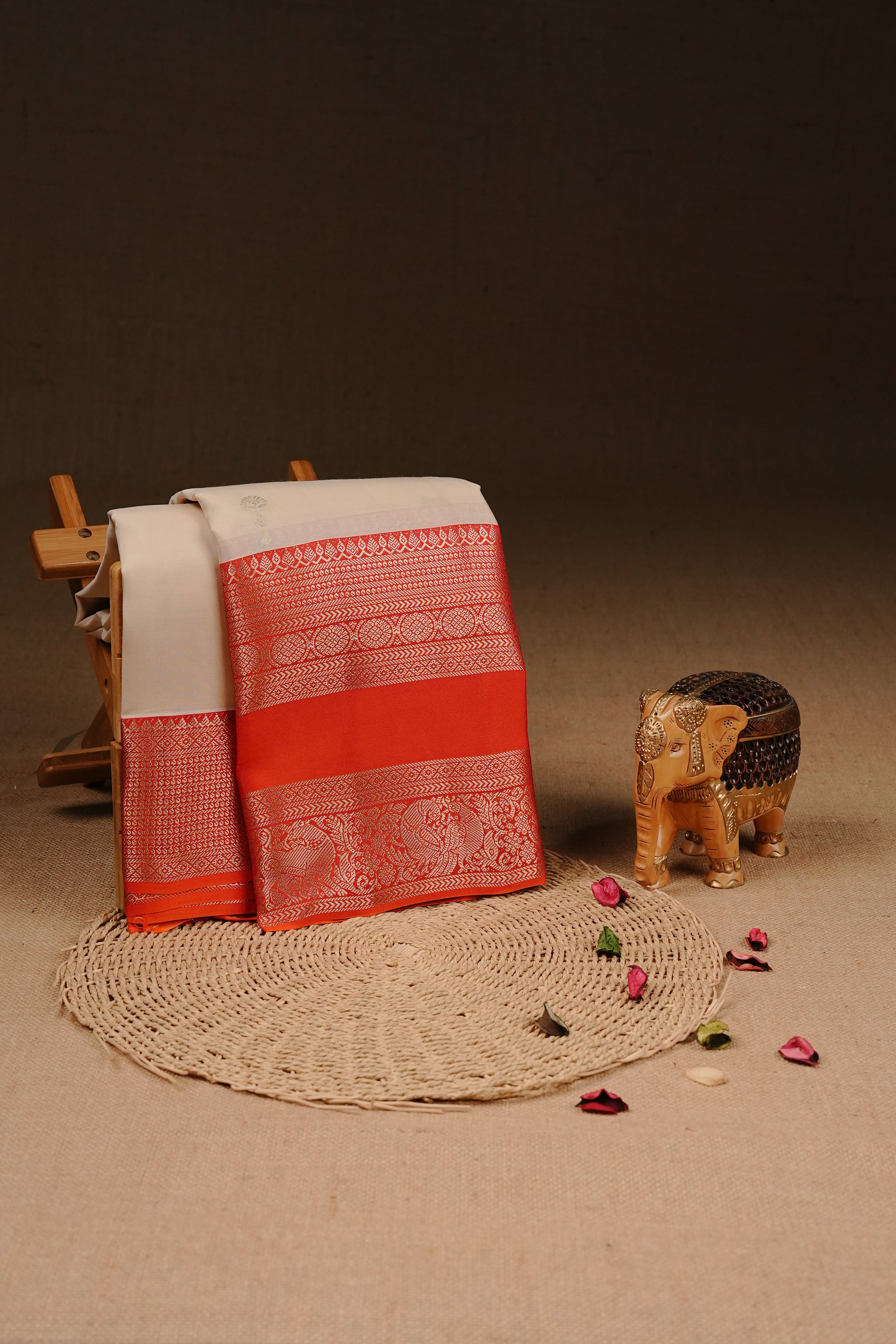 Cream colour Traditional Kancheepuram silk saree featuring gold zari motifs on body, enhanced with contrast Orange with traditional border, paired with matching blouse piece.