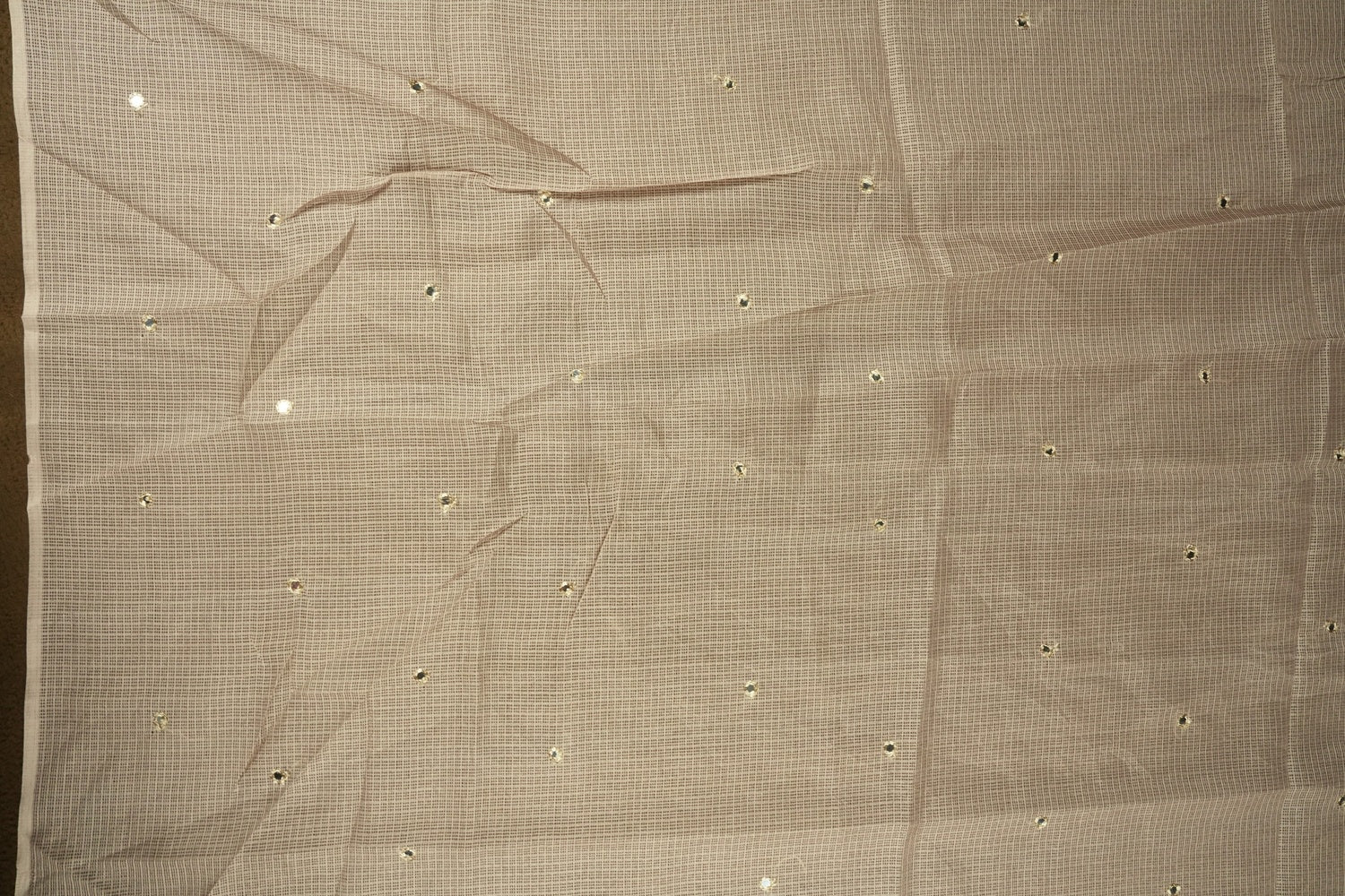 Beige colour Doriya check cotton saree with soft sequins work on the body, elegant embroidery scallop border, and a simple pallu & Comes with a matching plain blouse piece.