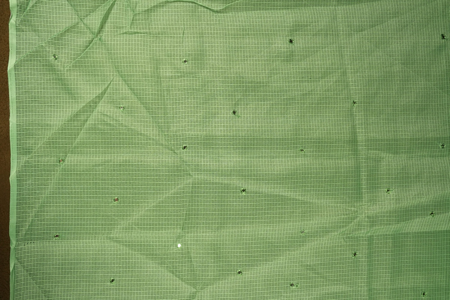 Green colour Doriya check cotton saree with soft sequins work on the body, elegant embroidery scallop border, and a simple pallu & Comes with a matching plain blouse piece.