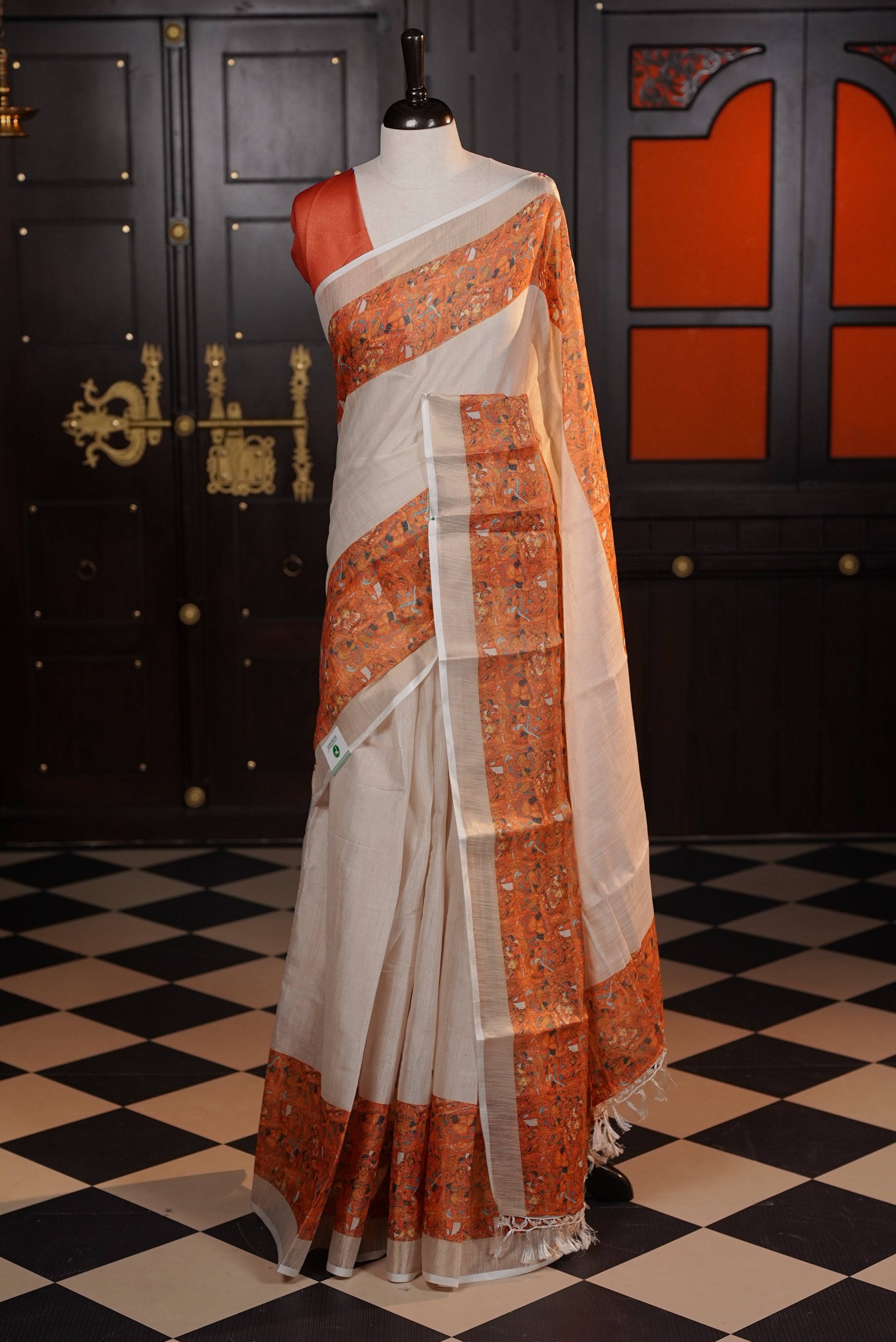 Light gold colour semi tissue silk saree with a Orange printed border, paired with a contrast blouse piece.