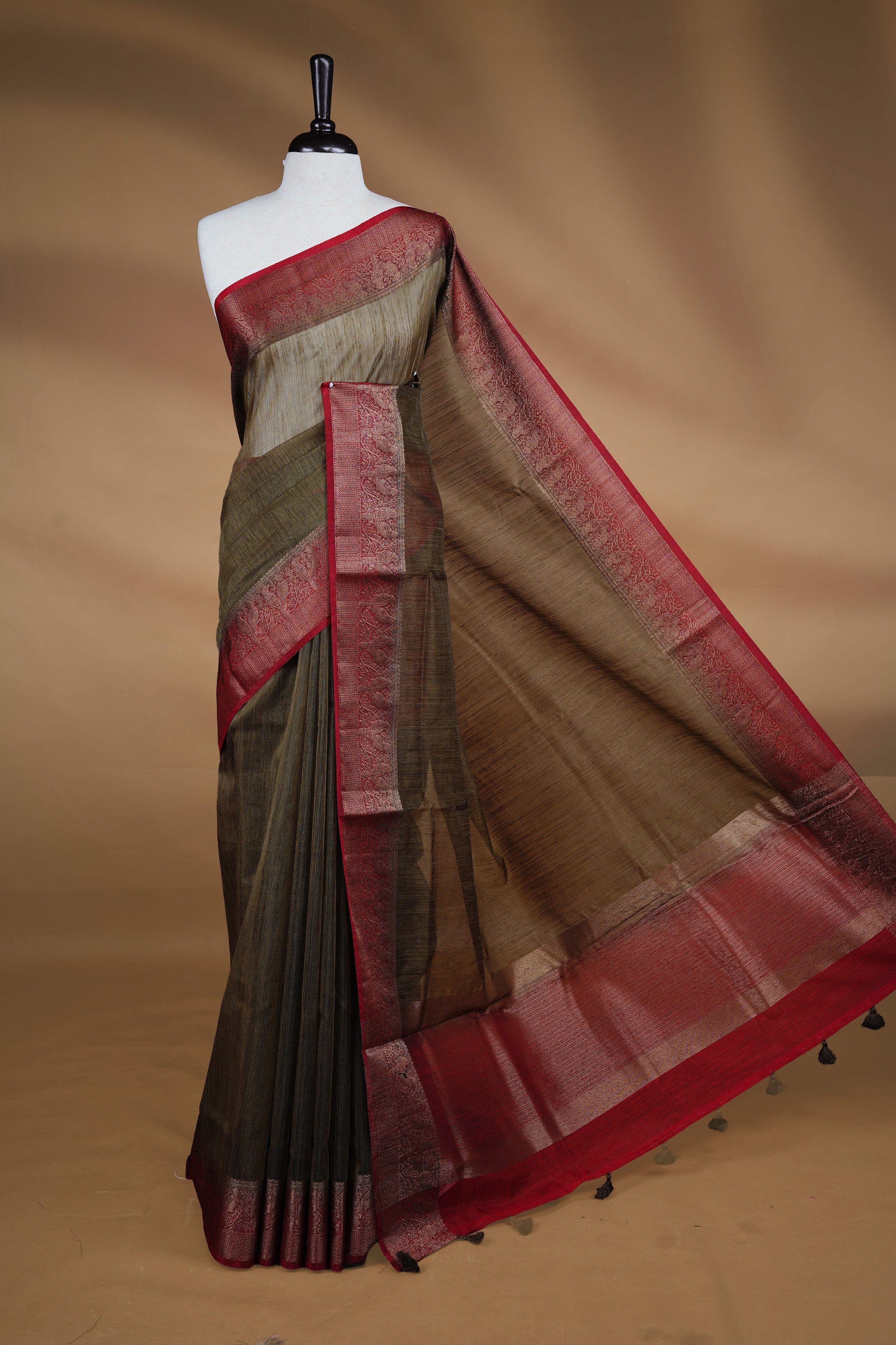 Bronze Olive colour Semi linen saree featuring Elegant plain body, complemented by contrast Green colour With Antique zari border, paired with matching blouse piece.