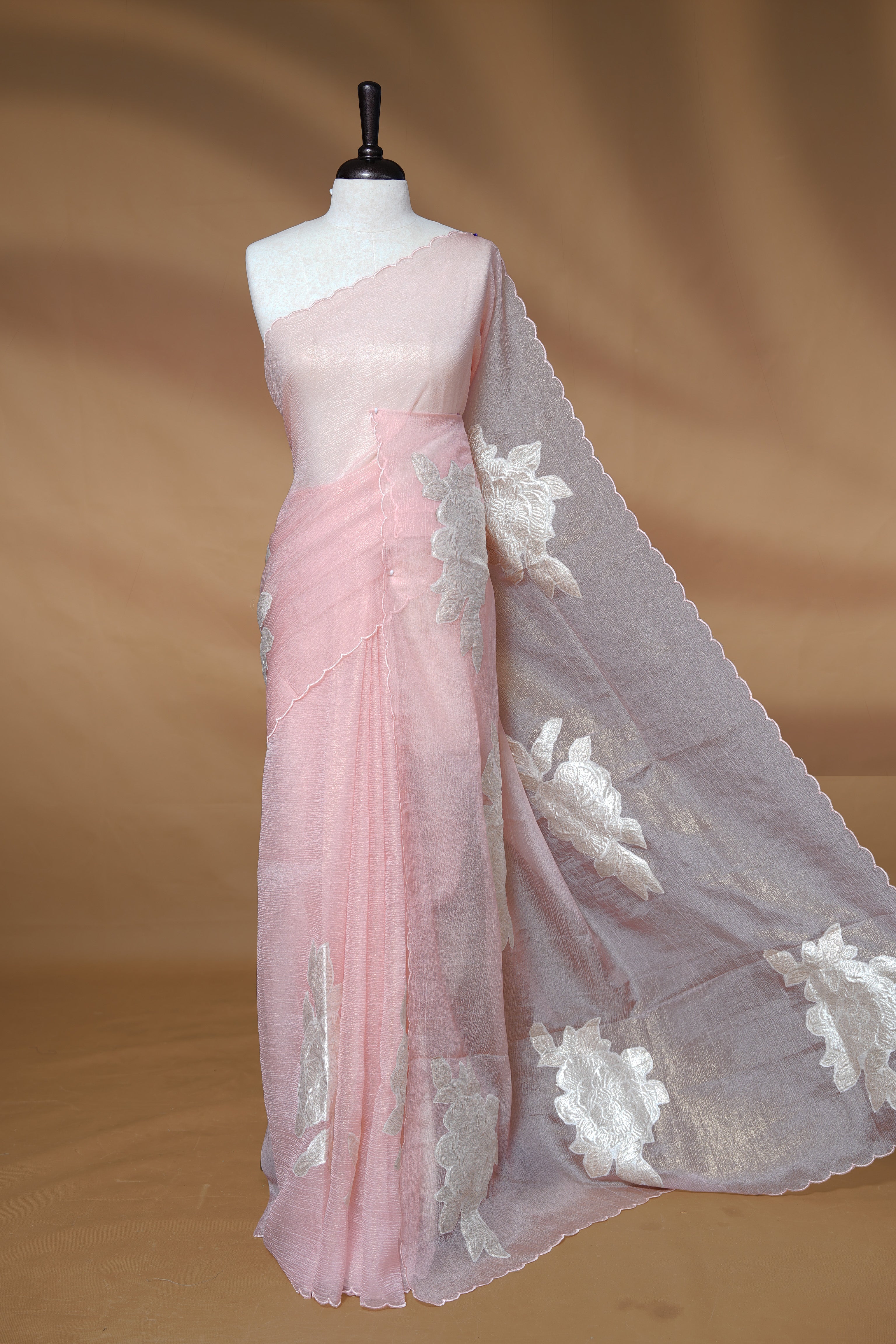 Pastel peach colour Crush Organza Saree featuring White floral Pattern on body, complemented by classy Thread border, paired with matching blouse piece.