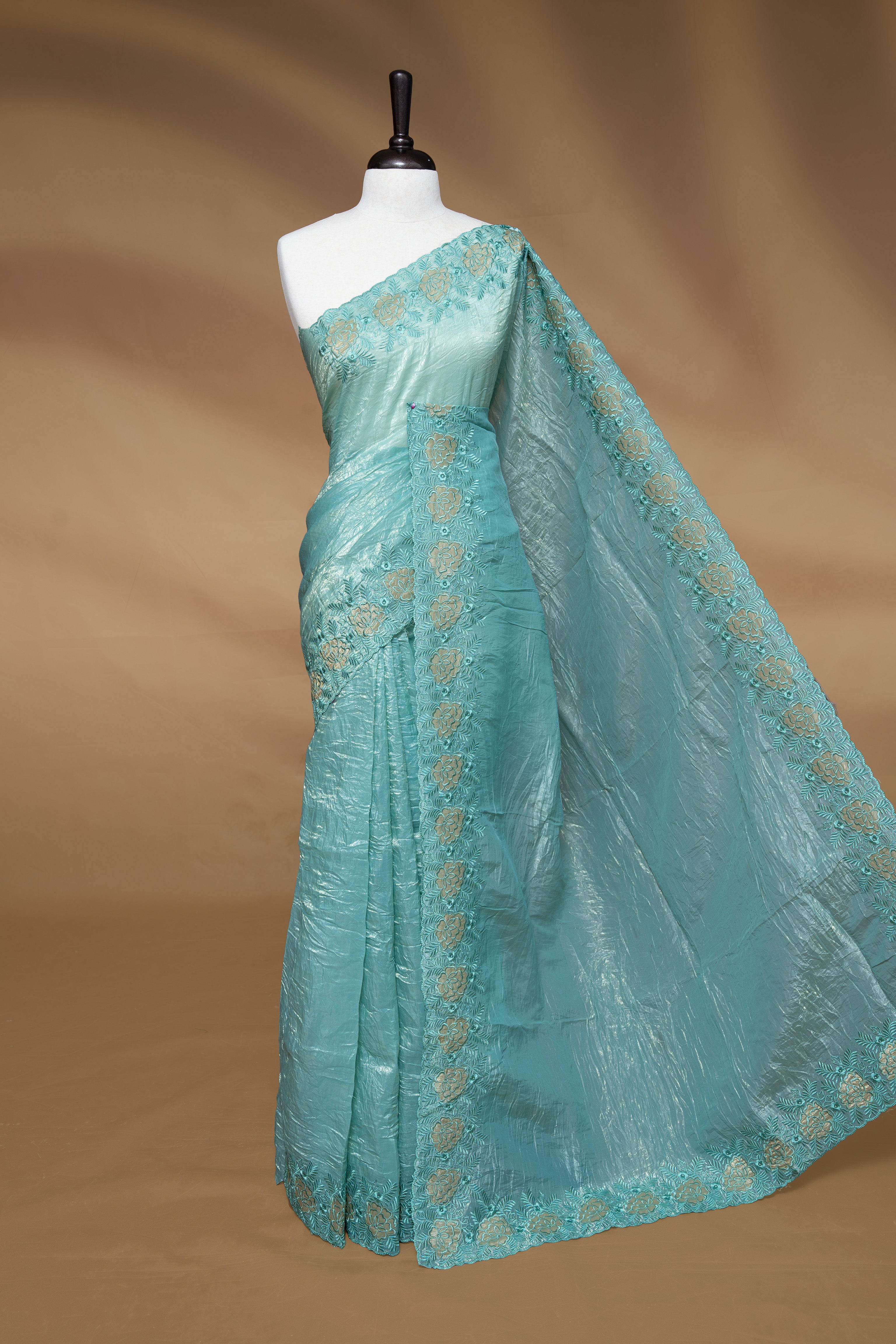 Aqua colour Crush Organza Featuring Plain body, Enrich with Floral thread pattern & scalp border, paired with matching blouse piece.