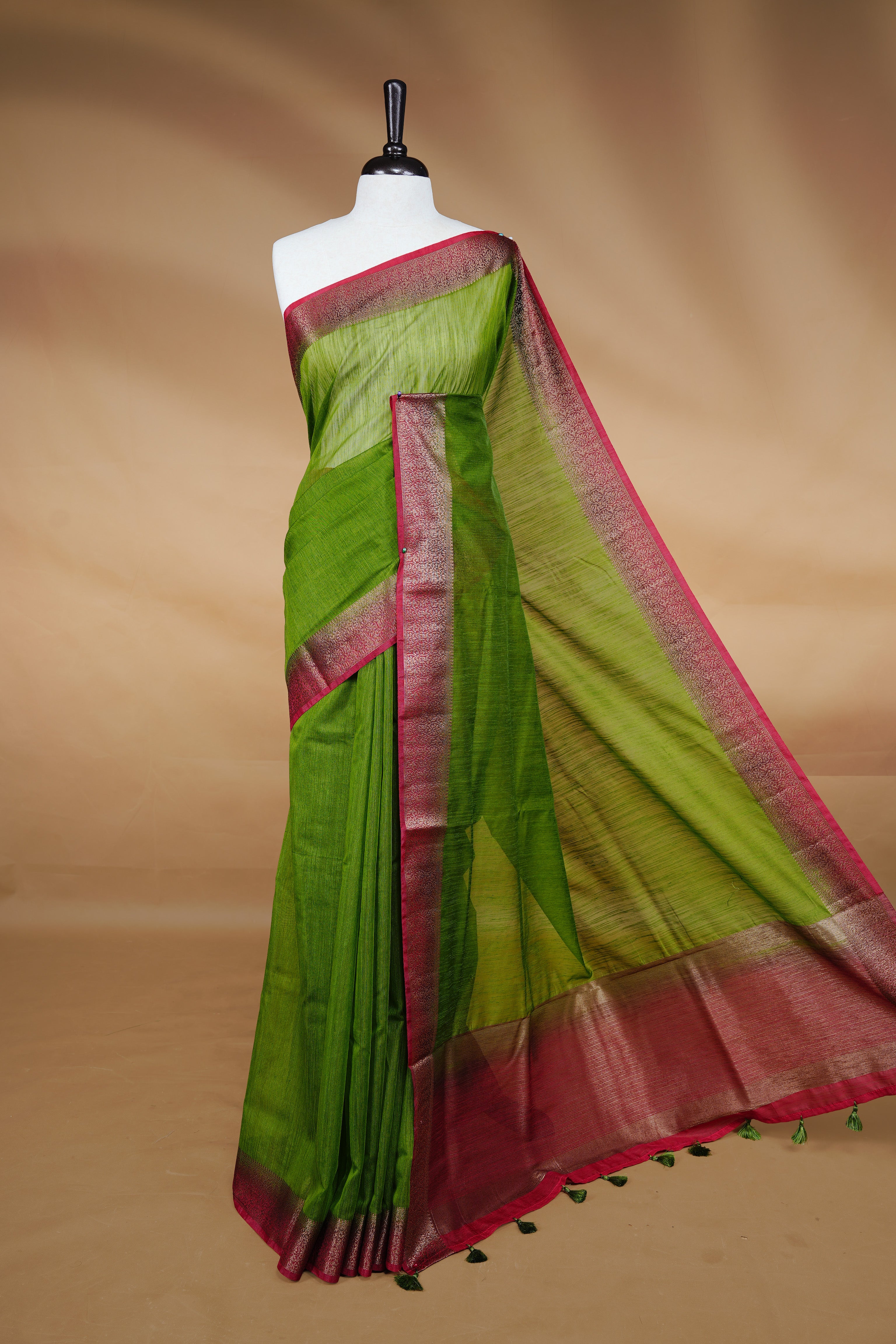 Green colour Semi linen saree featuring Elegant plain body, complemented by contrast Maroon colour With Antique zari border, paired with matching blouse piece.