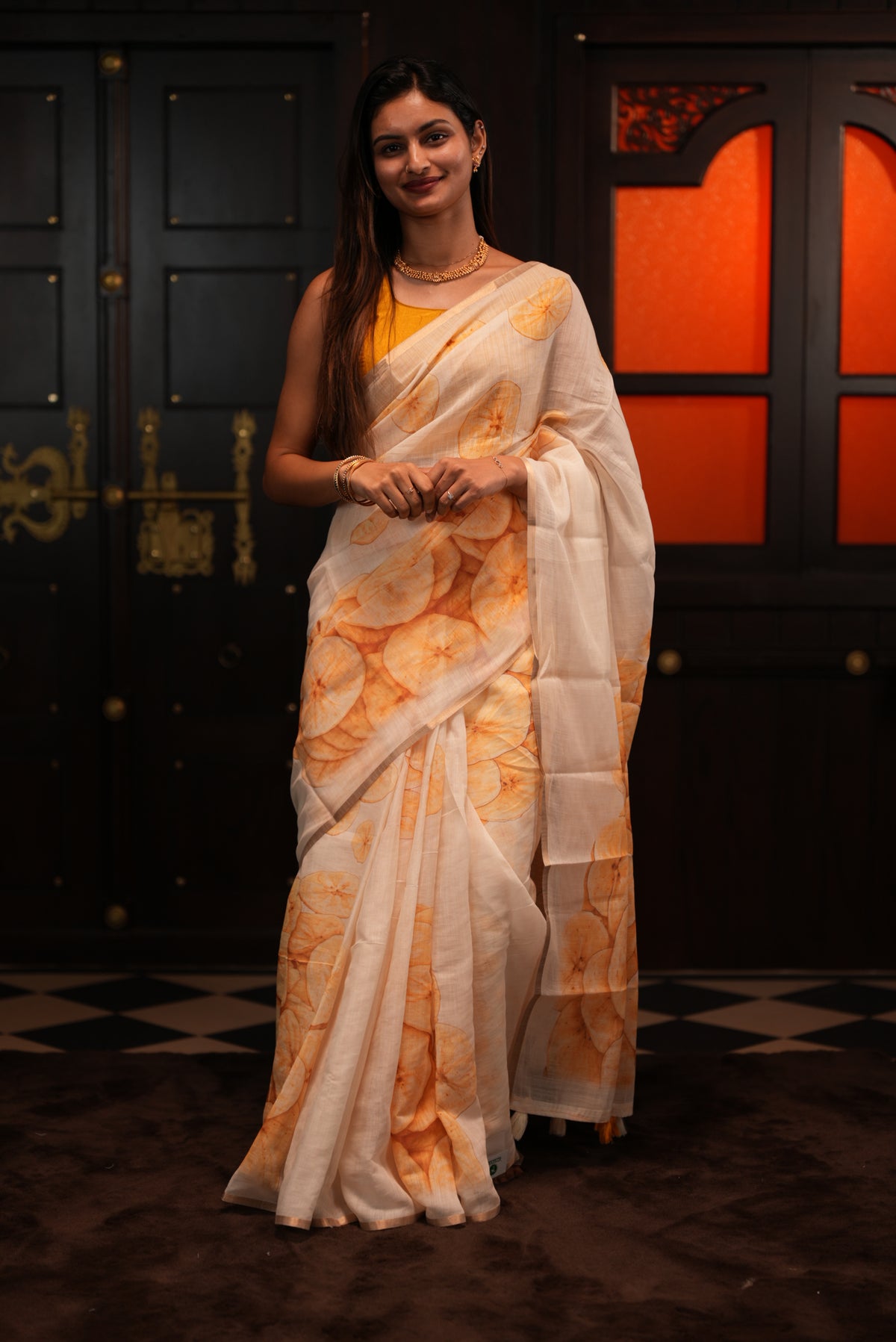 Cream colour Semi Linen saree featuring Banana Chips Print with Gold Tissue Border, comes with tassels.