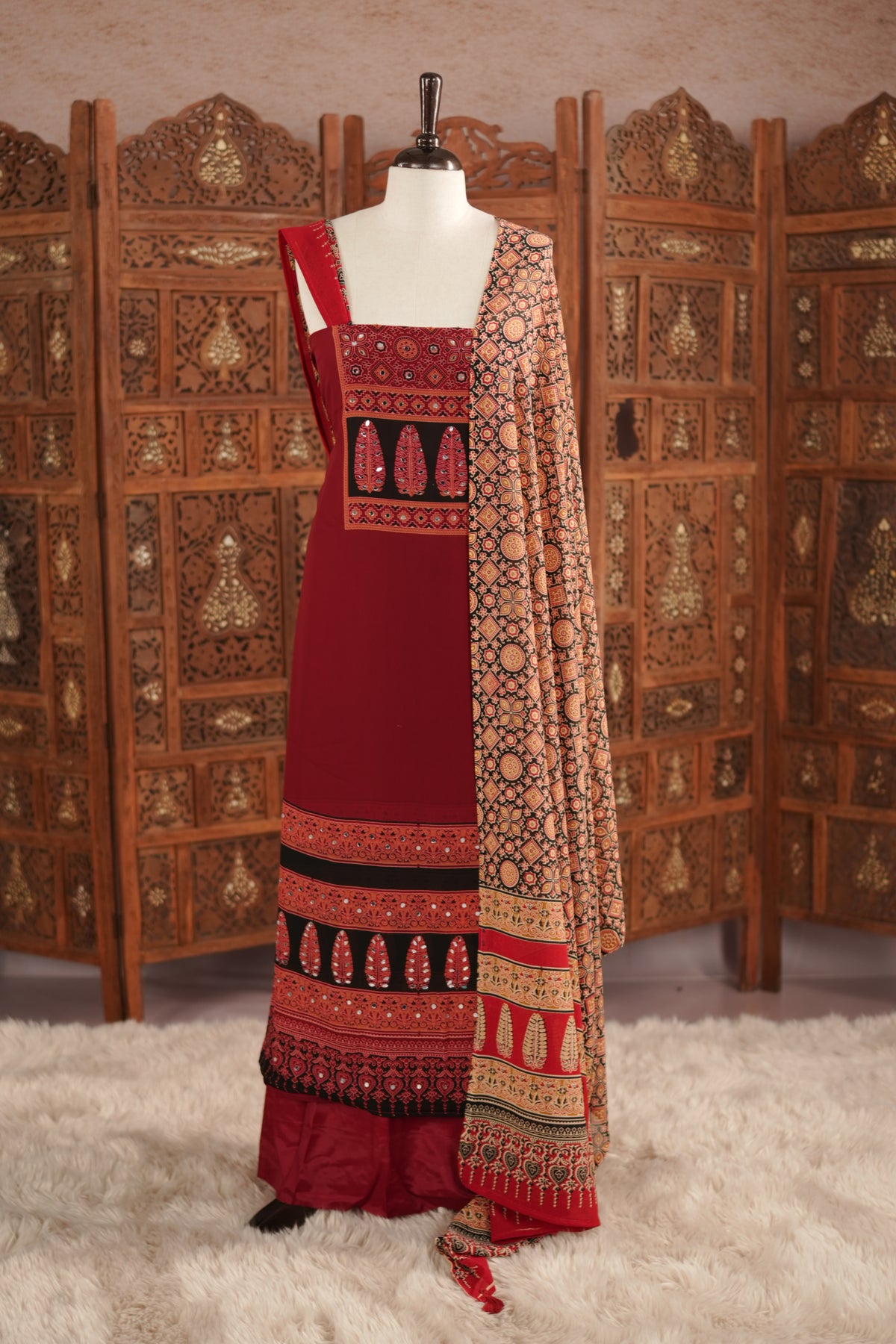 Maroon colour georgette salwar material featuring Daman Print Detailing Mirror work on neck portion, a dupatta with Same print , and Shantoon bottom.