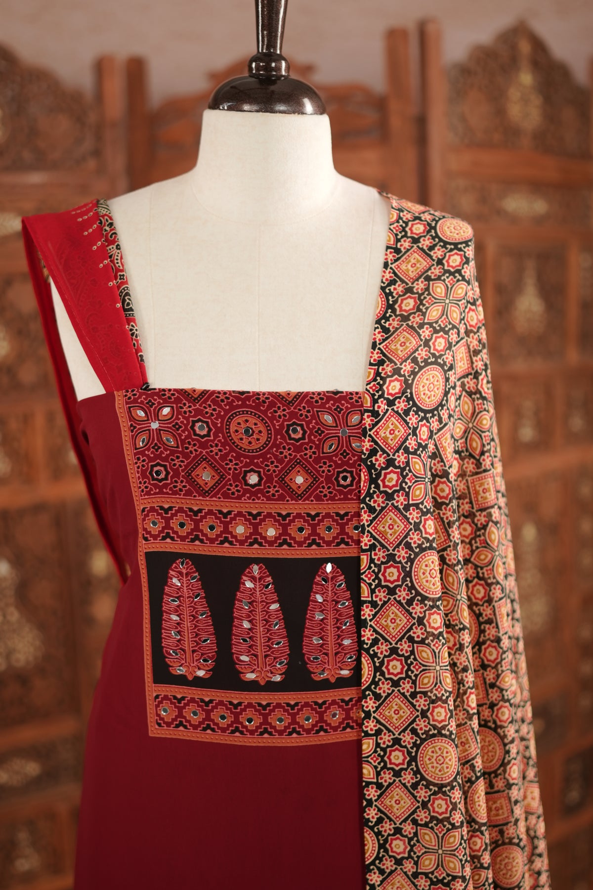 Maroon colour georgette salwar material featuring Daman Print Detailing Mirror work on neck portion, a dupatta with Same print , and Shantoon bottom.