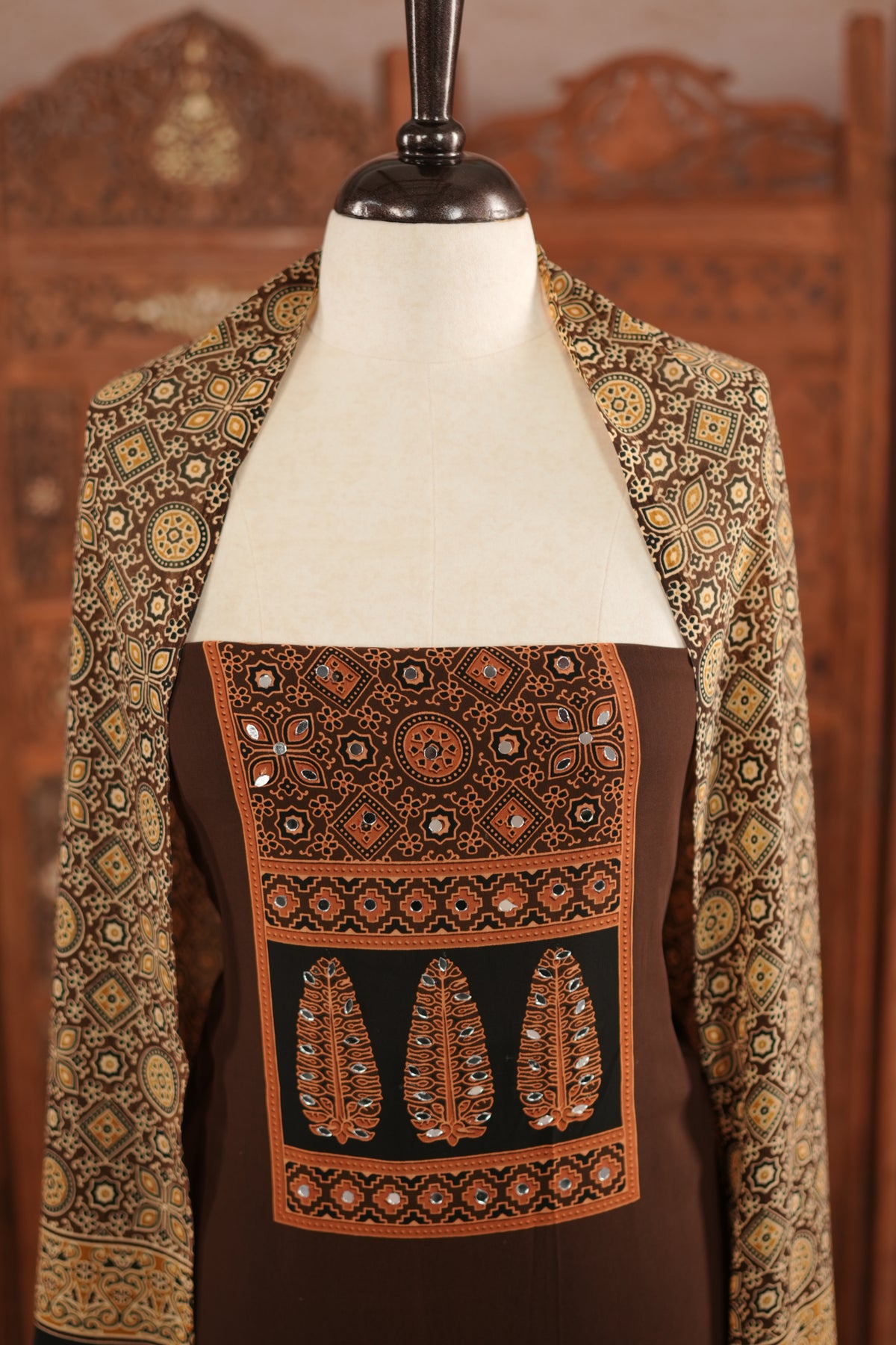 Coffee Brown colour georgette salwar material featuring Daman Print Detailing Mirror work on neck portion, a dupatta with Same print , and Shantoon bottom.