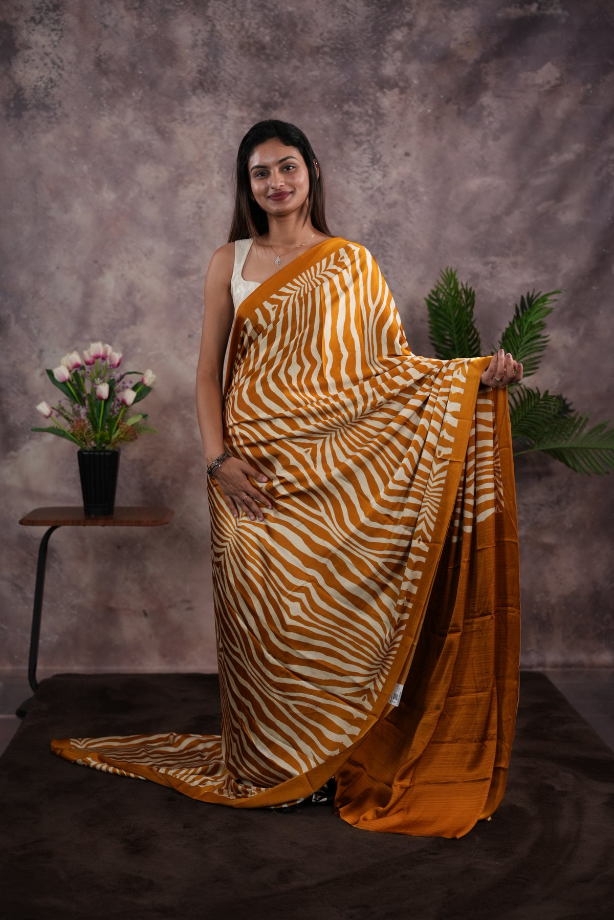 Mustard Yellow Colour satin model saree featuring Zibra print on body. Ajrak & zibra print on pallu with jhumka tassels, comes with contrast plain blouse piece.