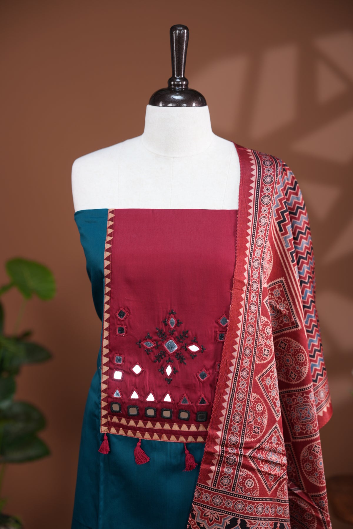Peacock blue colour Jam Satin salwar material, Plain body with mirror & thread work on neck portion, matching bottom and Dupatta with ajrak print.