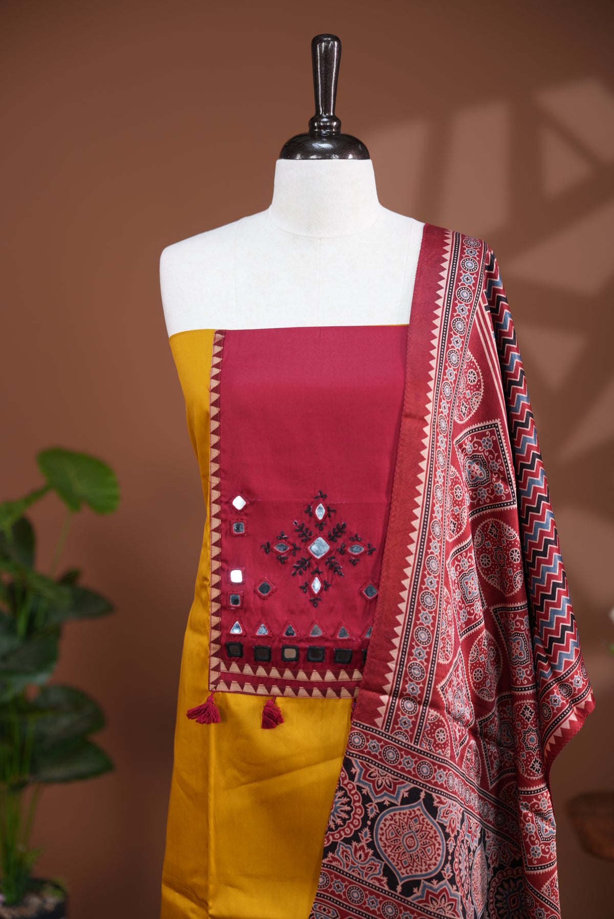 Mustard Yellow colour Jam Satin salwar material, Plain body with mirror & thread work on neck portion, matching bottom and Dupatta with ajrak print.