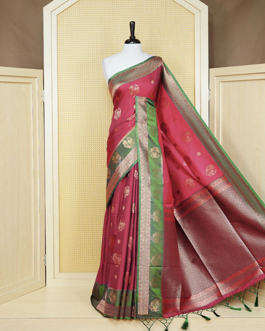 Red colour Mulberry silk saree featuring floral gold zari patterns on body, paired with contrast Green colour with traditional border, comes with matching blouse piece.
