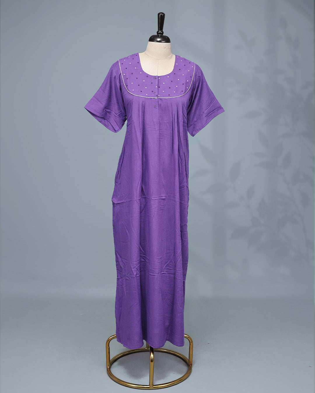Elegant solid purple nighty featuring a round neckline with embellished yoke, delicate contrast piping, front button placket & half sleeve and a relaxed full-length fit for all-day comfort and graceful everyday wear.