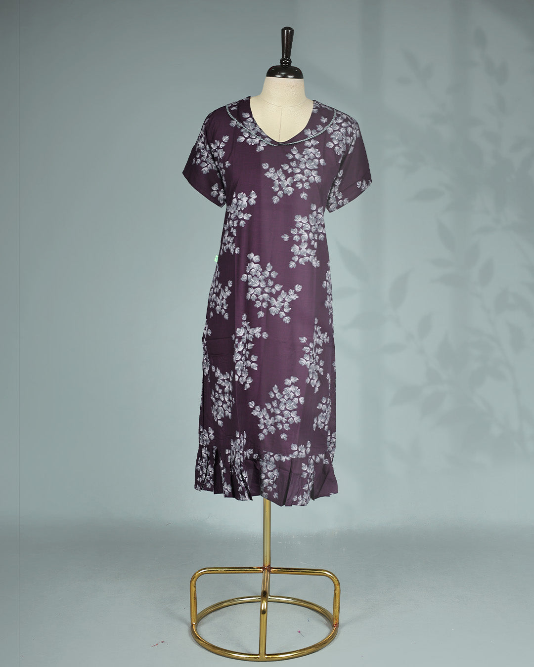 Dark Purple colour nighty featuring white floral prints on body, a round neckline with lace trim, short sleeves, and a ruffled mid-length fit