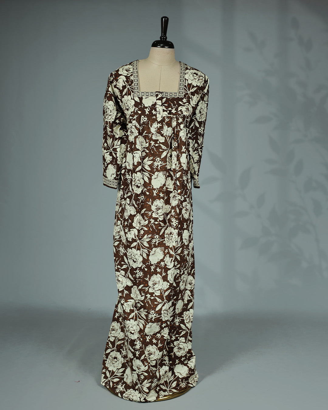Olive Brown colour nighty featuring cream floral prints on body , an openable button-front square neckline with a printed border, three-quarter sleeves, front gathers and an ankle-length fit.