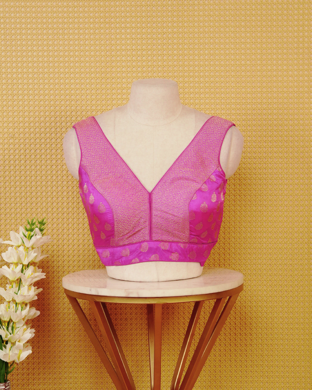 Magenta colour Sleeveless Blouse Featuring A Stylish V-Neck, Elegant Woven Pattern With Gold Butta Motifs, And A Comfortable Tailored Fit.