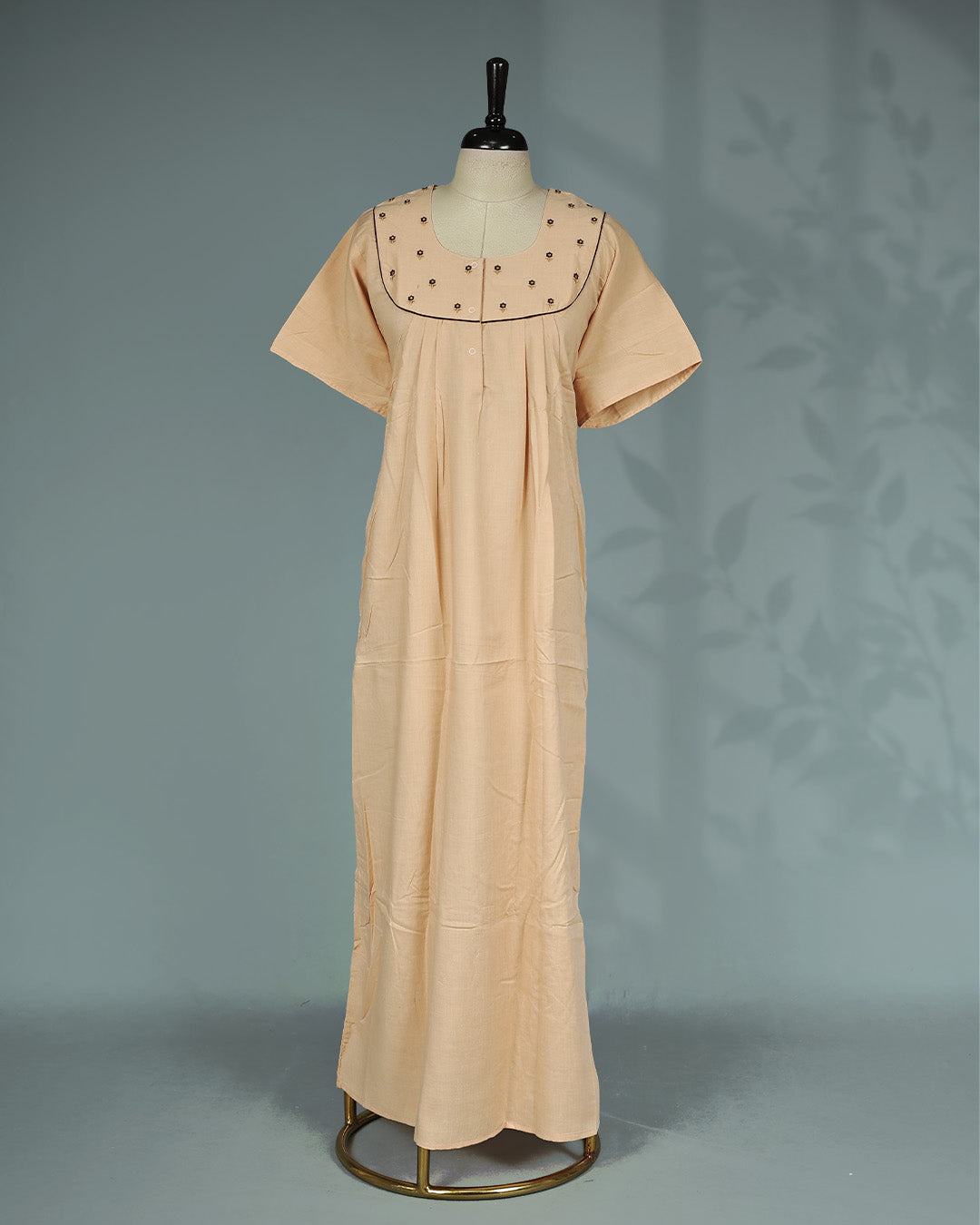 Peach solid nighty with a classic square neckline, short sleeves, delicate floral embroidery on the yoke, subtle contrast piping, and a relaxed full-length for everyday comfort and elegant simplicity.