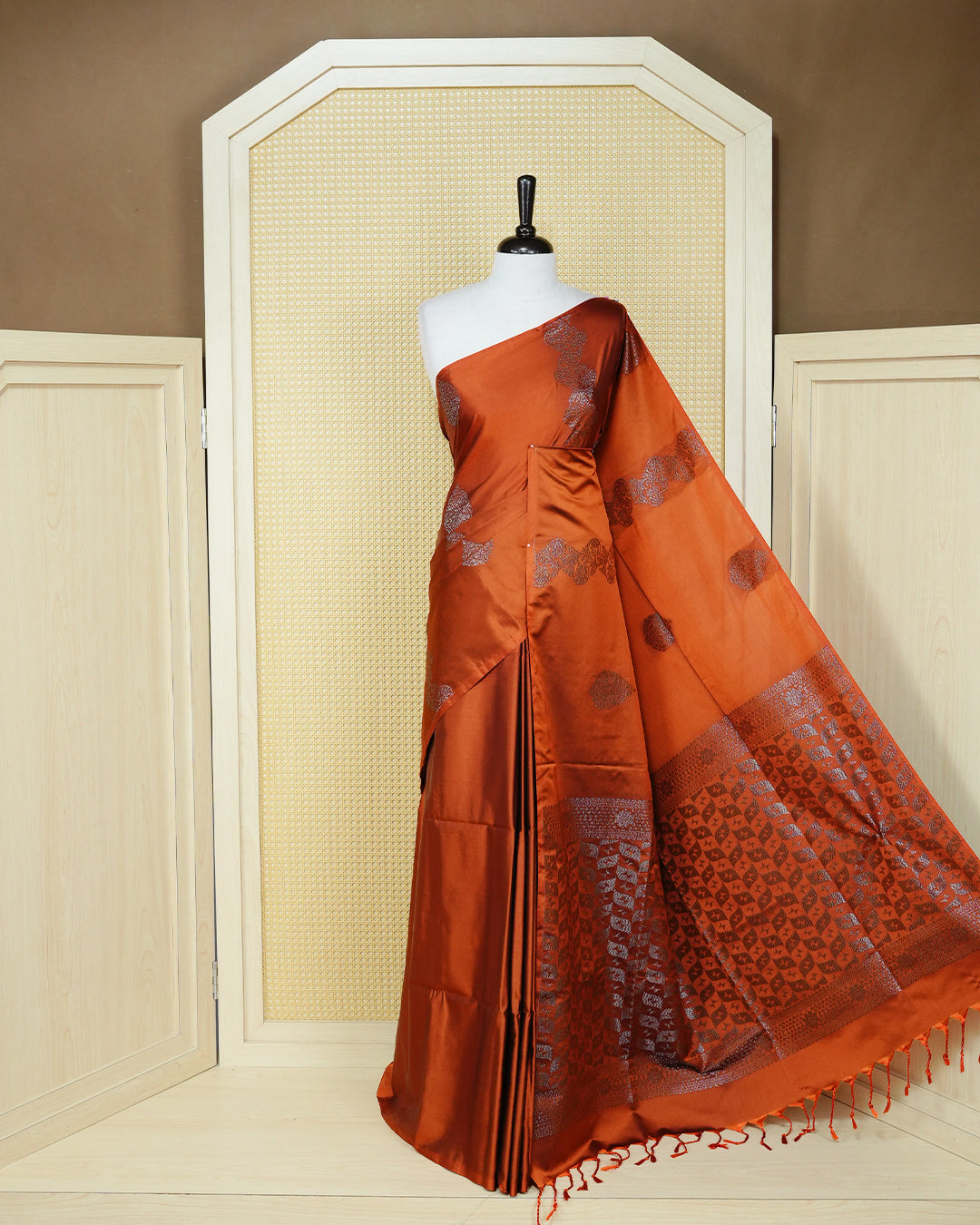 Rust orange colour soft silk saree featuring antique zari motifs on body with contrast self colour pallu & paired with matching blouse piece.