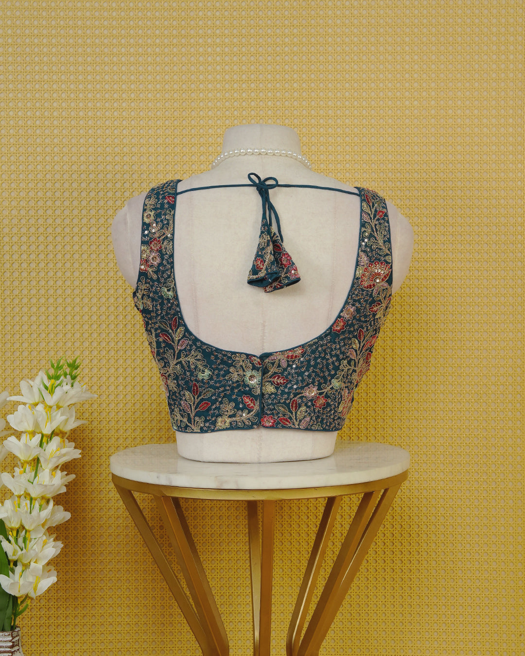 Blue colour Embroidered Sleeveless Blouse Featuring A Stylish V-Neck, Intricate Floral Embroidery With Sequin Detailing, And A Comfortable Tailored Fit.