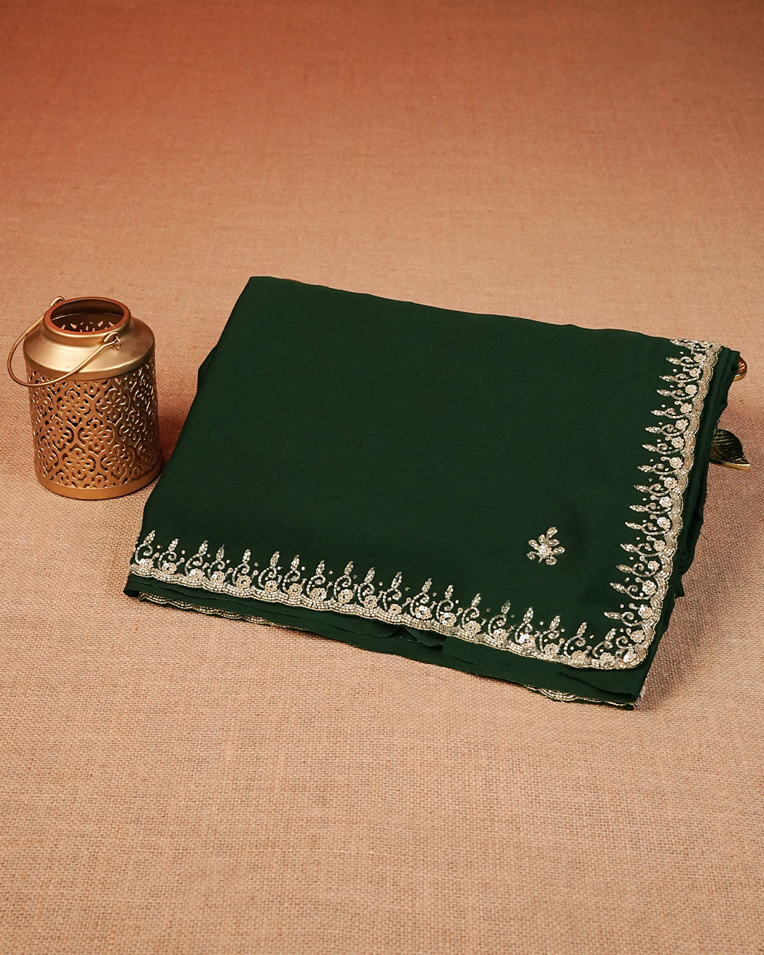 Bottle green designer saree featuring intricate bead and sequin work on the border, paired with a matching blouse piece.