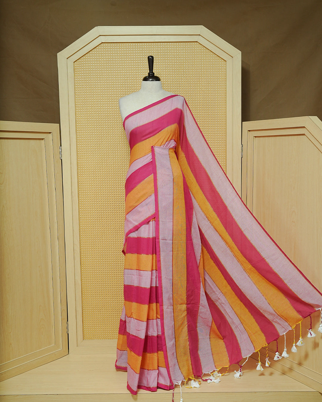 Pink & Mustard Colour Mul Cotton Saree featuring bold striped patterns in Magenta, mustard, and soft pink, accented with subtle zari lines and finished with white tassels.