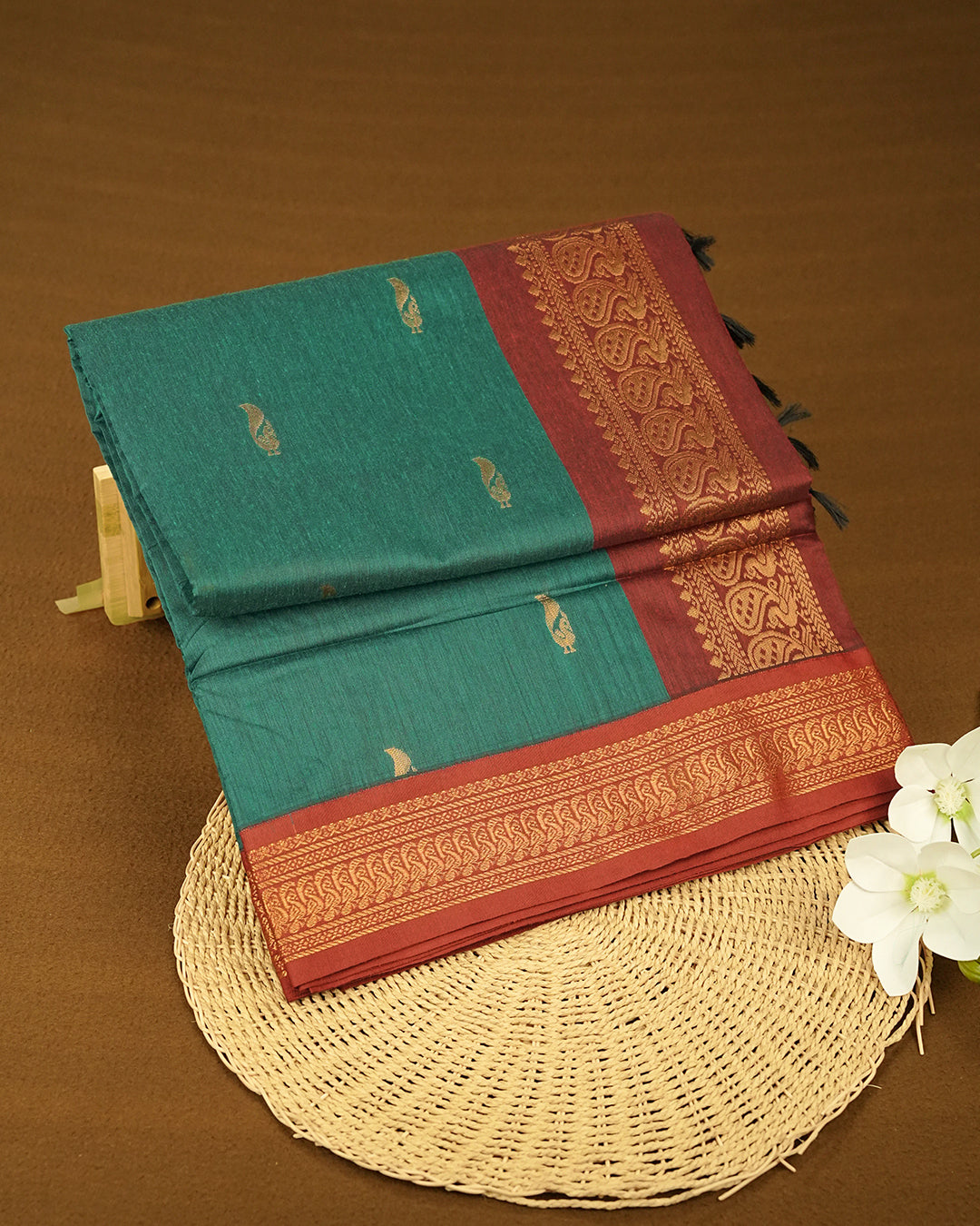 Peacock Green Colour Kalyani cotton saree featuring elegant antique zari peacock butta motifs on the body, complemented by a Maroon contrast pallu with a rich antique zari border, paired with a matching blouse piece