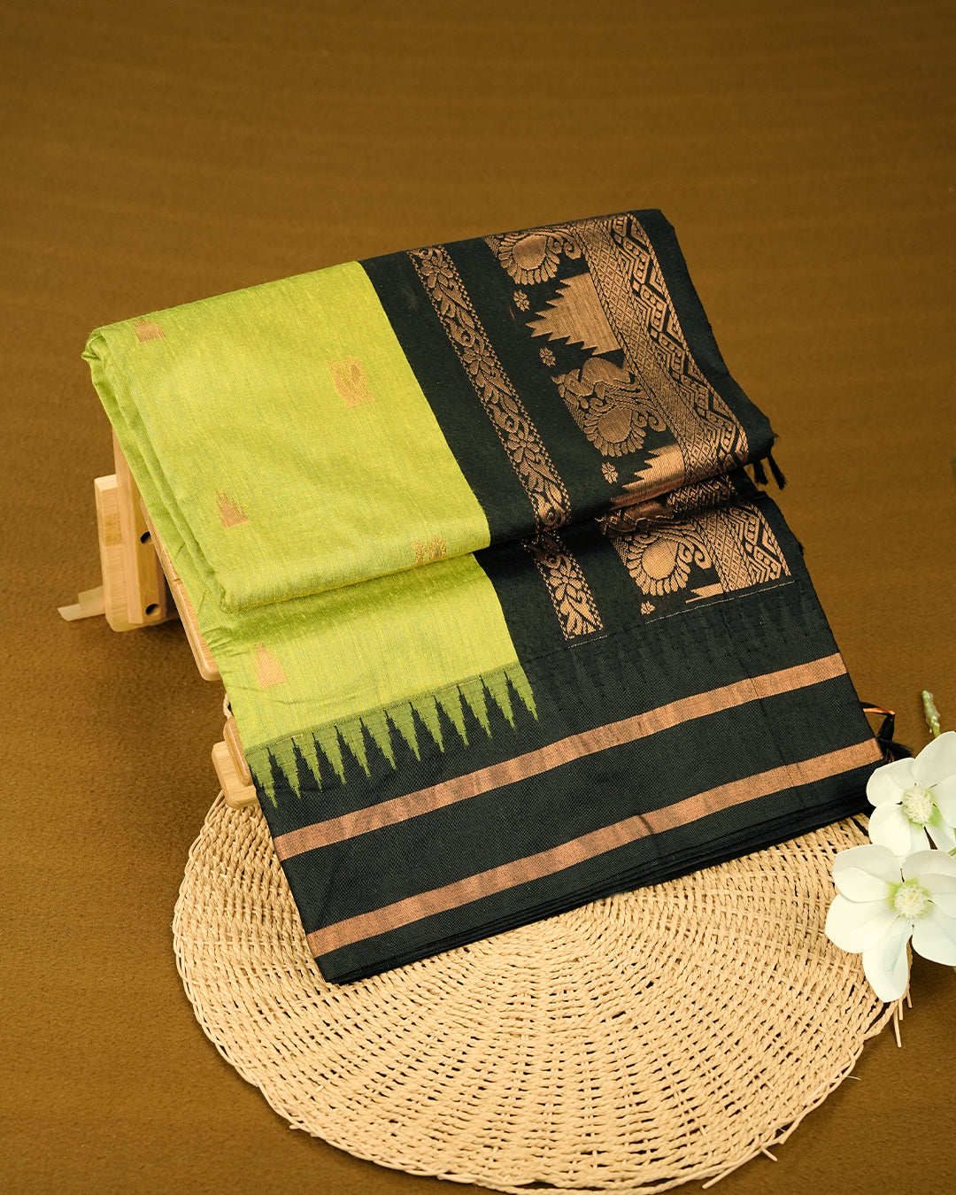 Light Green colour kalyani cotton saree featuring gold zari Motifs on body, complemented by Black colour with Gold zari border, paired with matching blouse piece