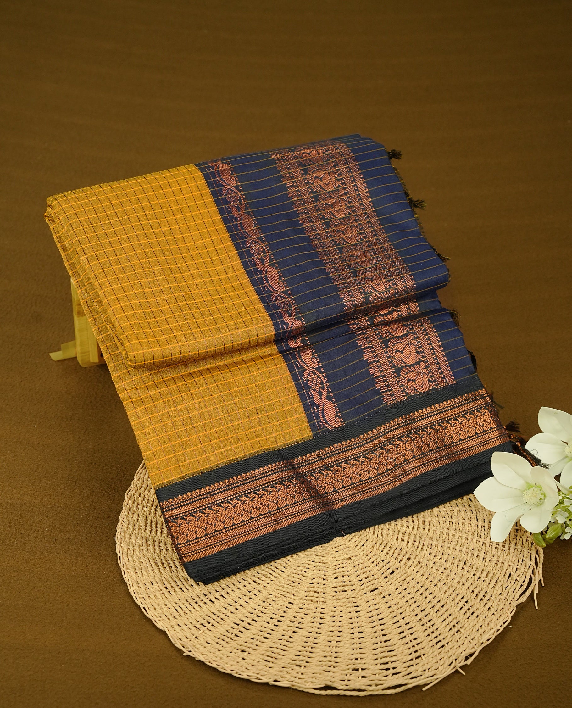 Mustard colour kalyani cotton saree featuring Copper zari check pattern on body, complemented by Navy Blue colour with Antique Copper zari border, paired with matching blouse piece