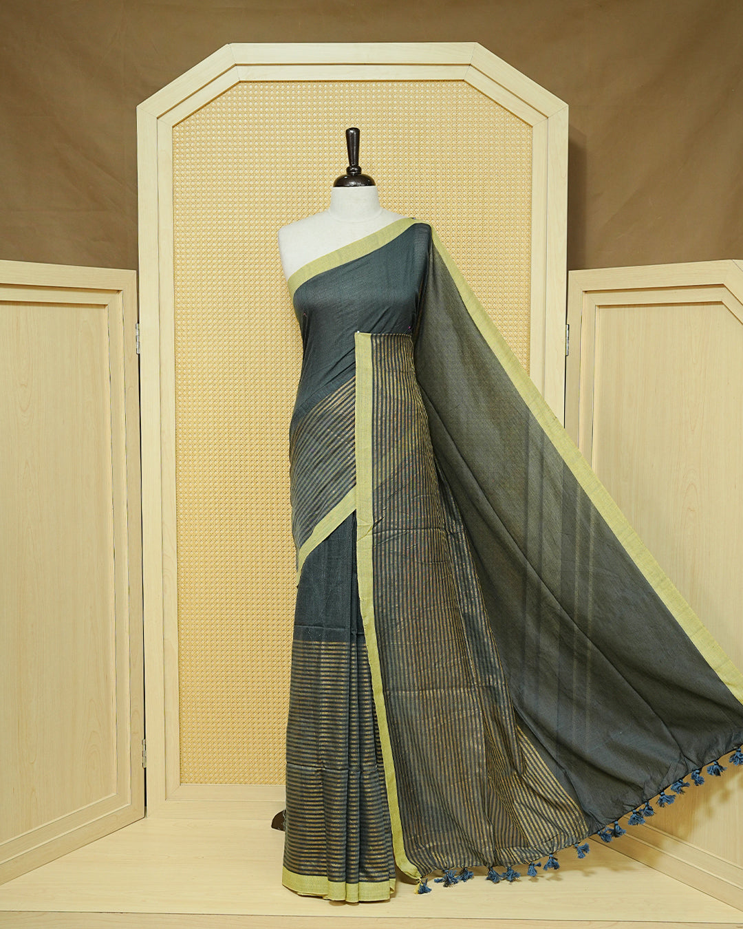 Grey Colour Half & Half Mul cotton saree featuring Gold zari Stripes on one side, Complemented by contrast Green colour Border & tassels.