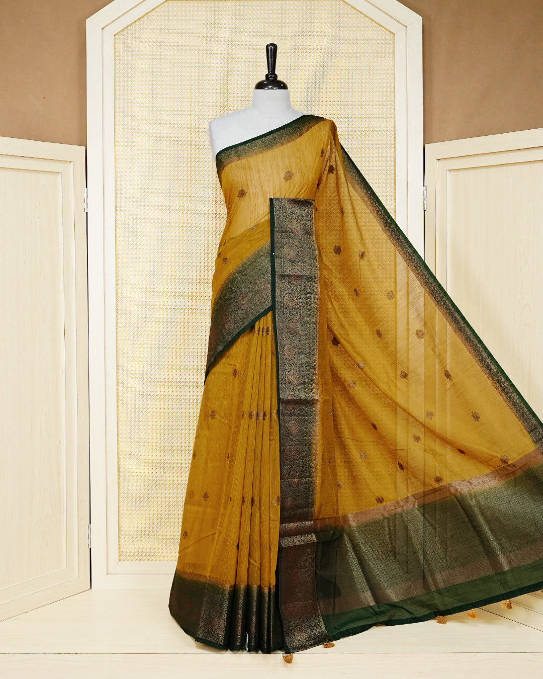 Mustard yellow colour semi linen saree thread motifs on body, contrast bottle green colour gold zari border, rich pallu comes with matching blouse piece