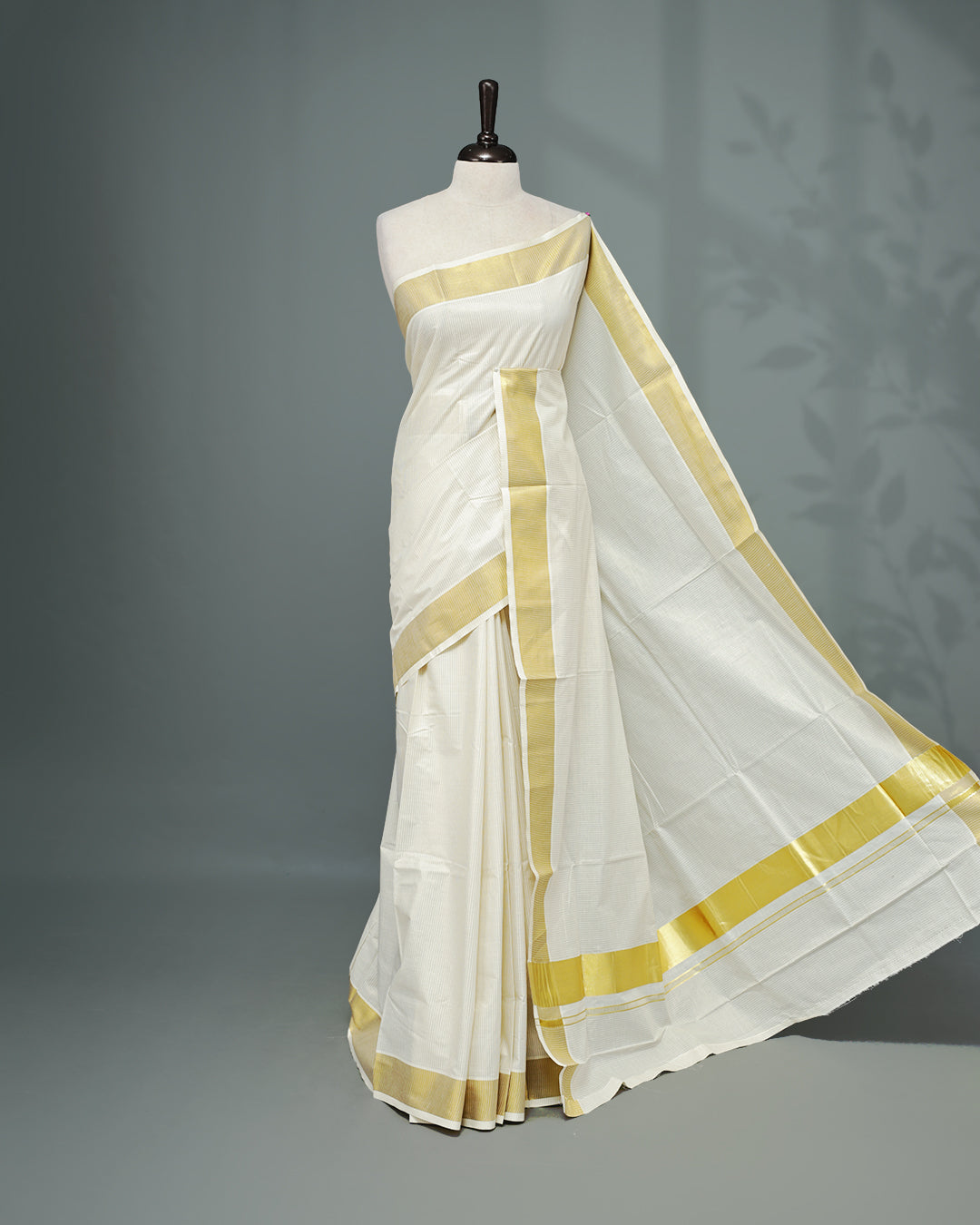 Cream colour Kerala saree Featuring Gold zari stripes on the body, complemented by a classic gold zari border, matching blouse piece.