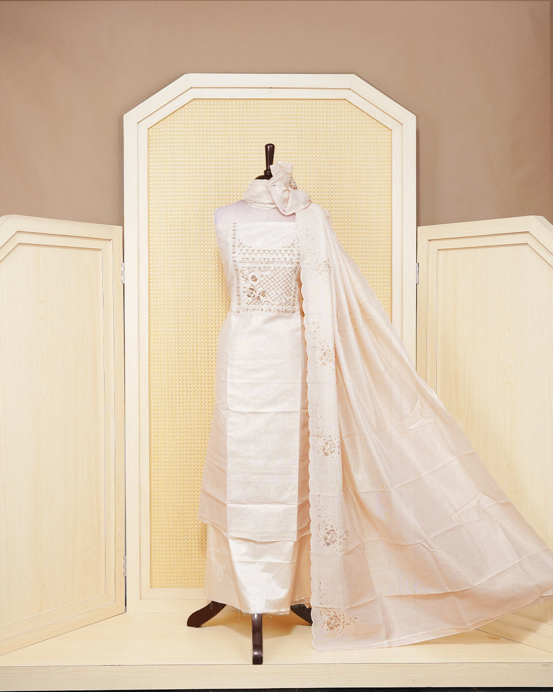 Cream colour tissue salwar material featuring an elegant floral pattern on body, beadwork on chest portion, paired with a matching bottom and an elegant dupatta.