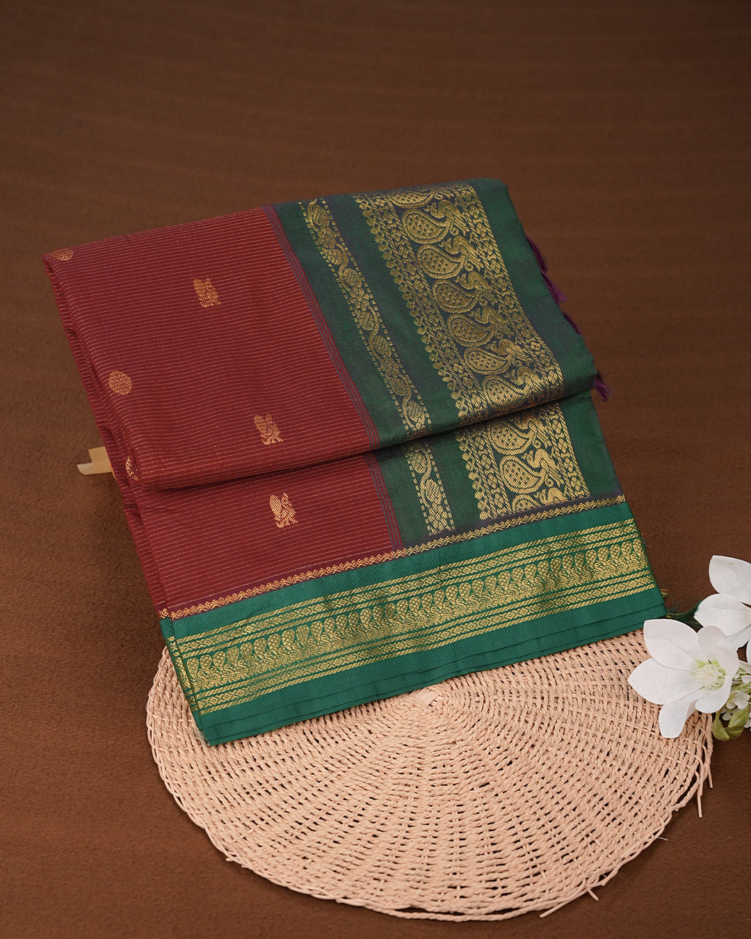 Maroon colour kalyani cotton saree featuring gold zari Stripes on body, complemented by Green colour with Antique zari border, paired with matching blouse piece